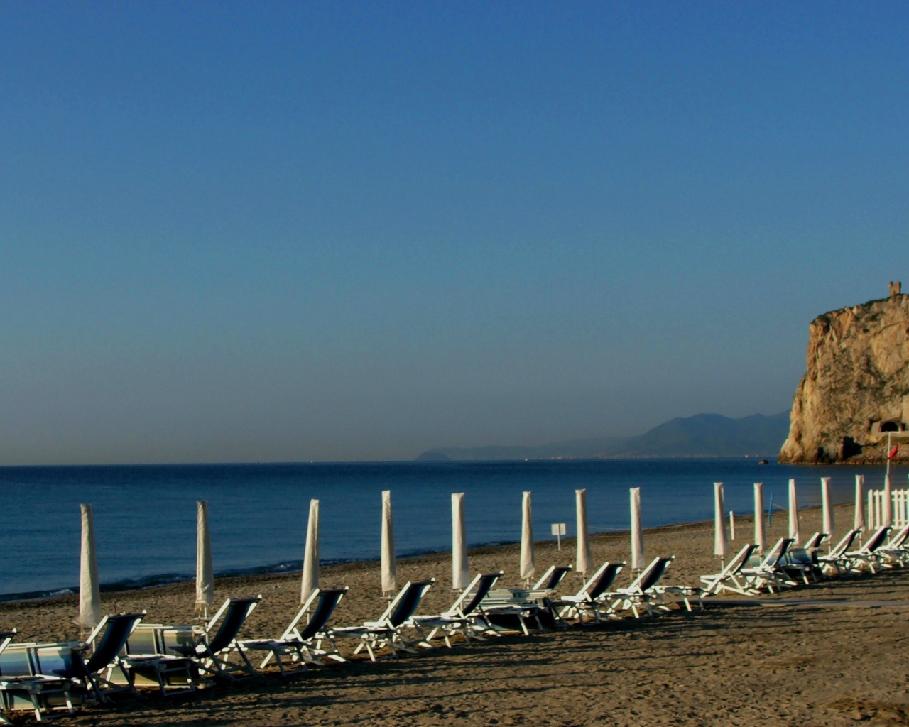 Лежаки на пляже на курорте Финале Лигуре, Италия