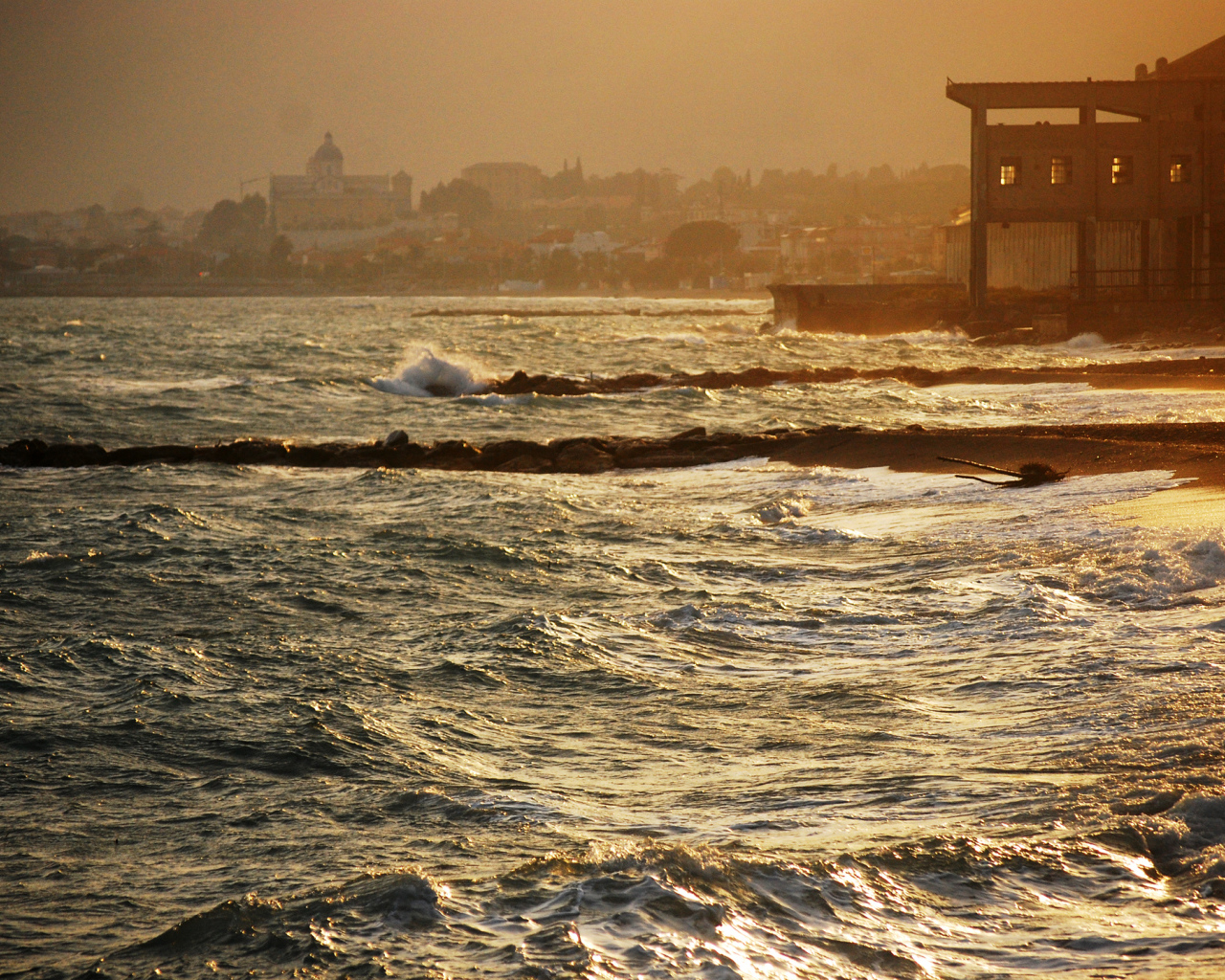 Закат на пляже на курорте в Пьетра Лигуре, Италия