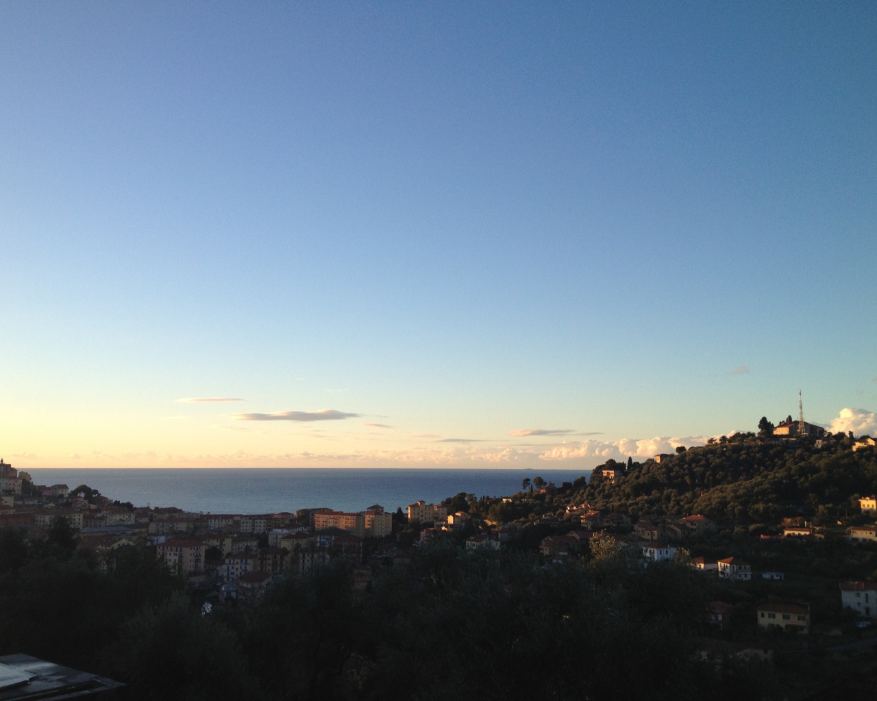 Закат над городом на курорте Империя, Италия