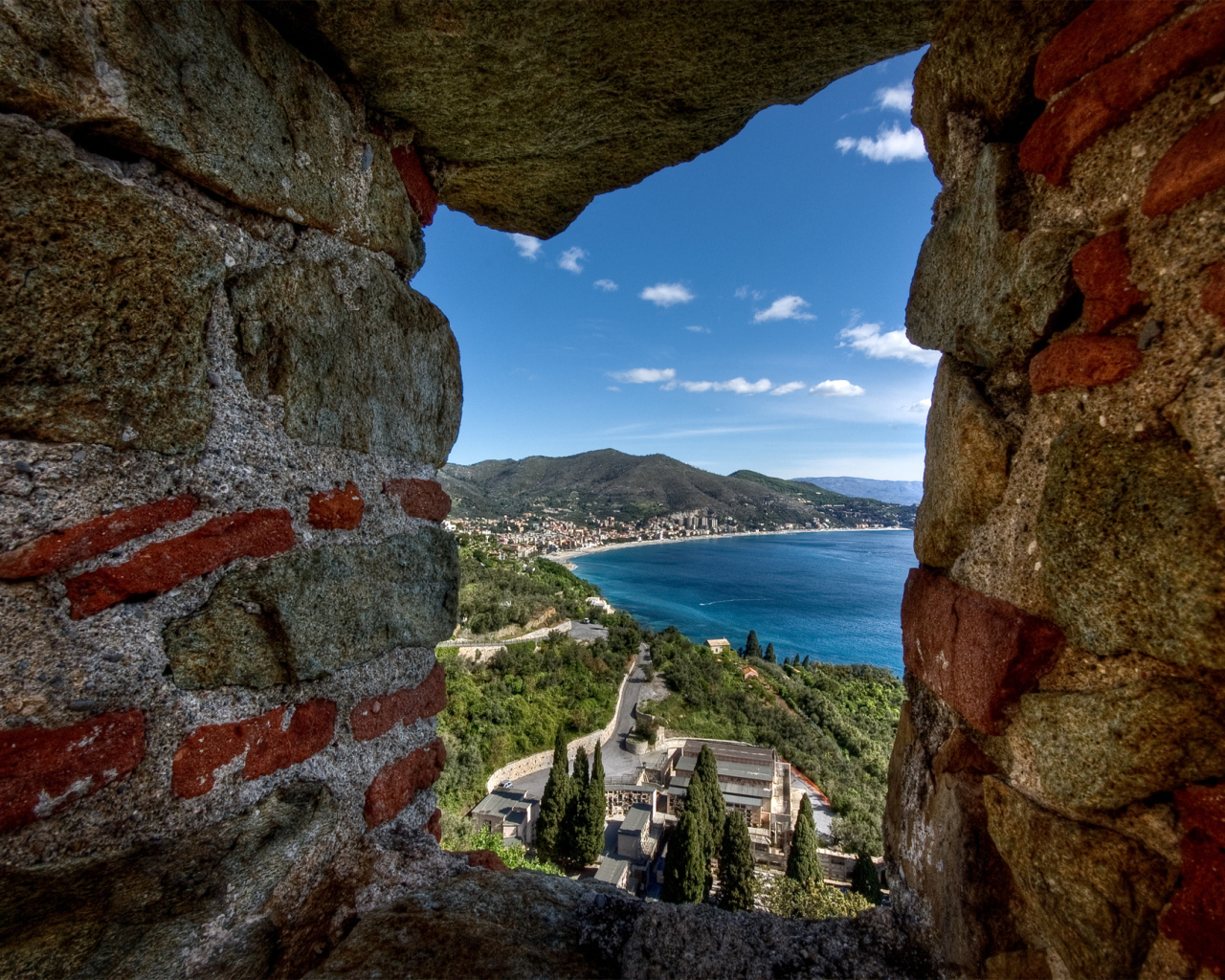 Вид через окно бойницы на курорте Ноли, Италия