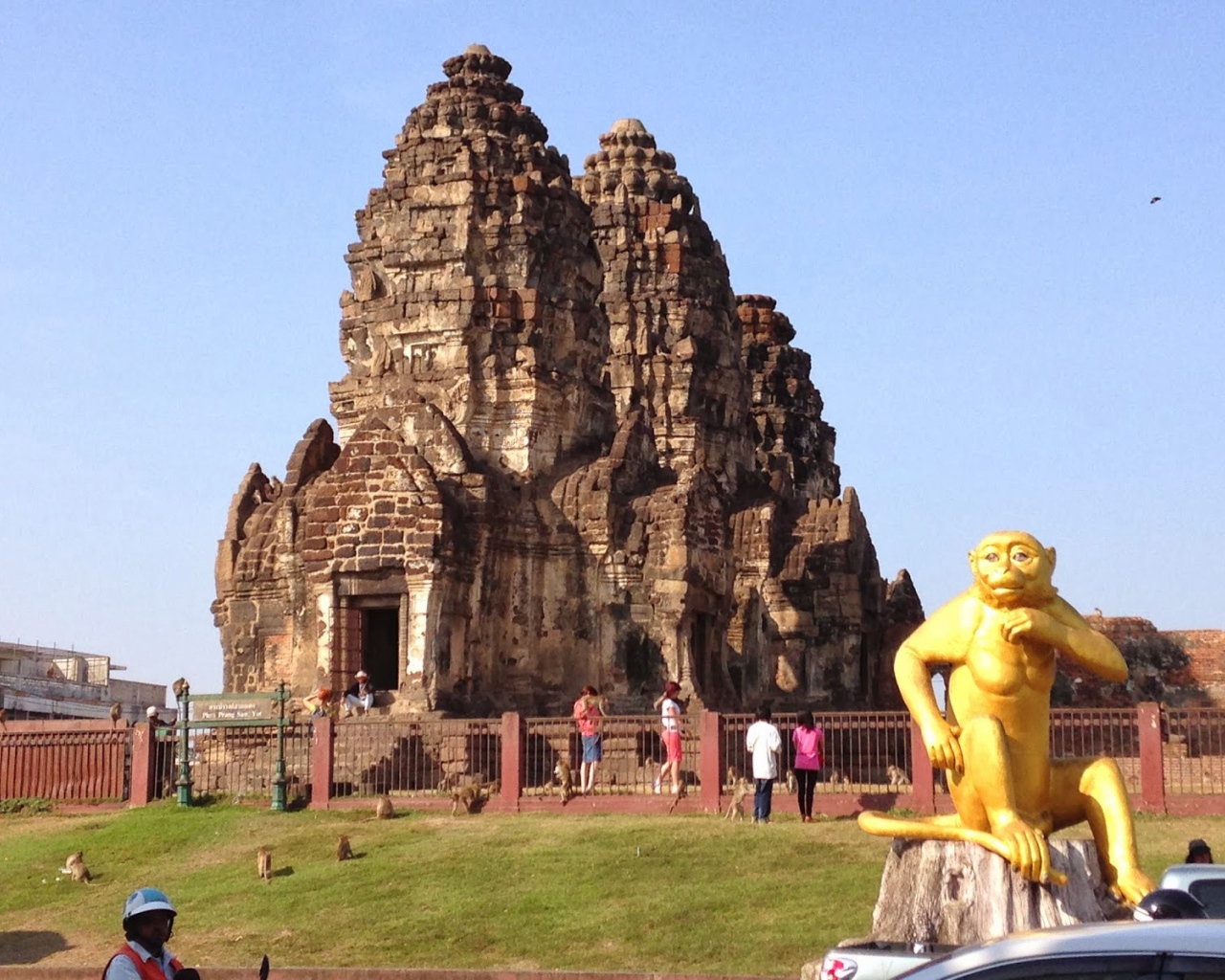 Золотая обезьяна на фоне храма на курорте Лопбури, Таиланд