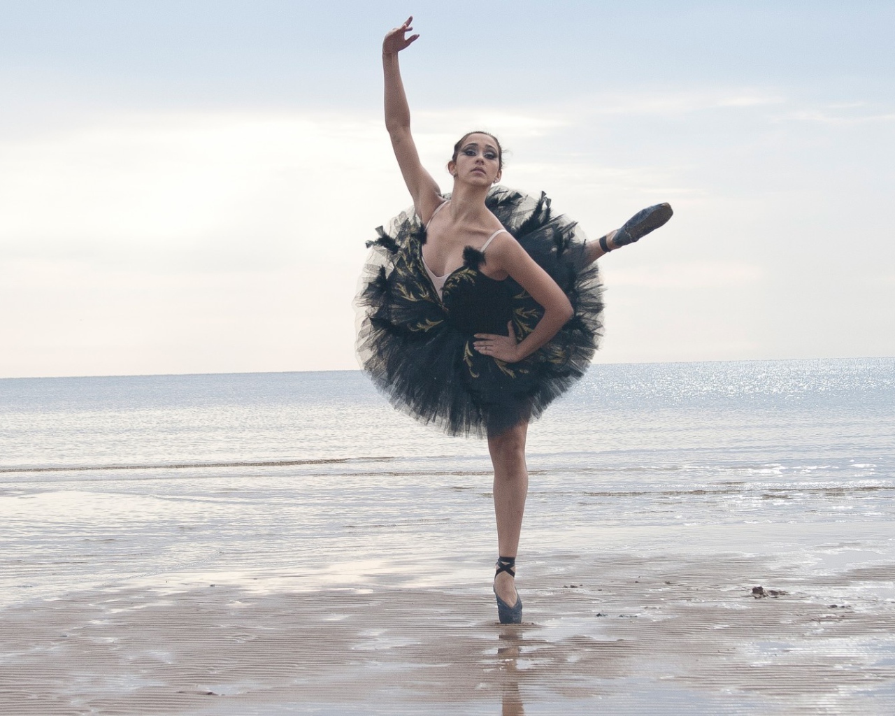 Балерина в черном на пляже