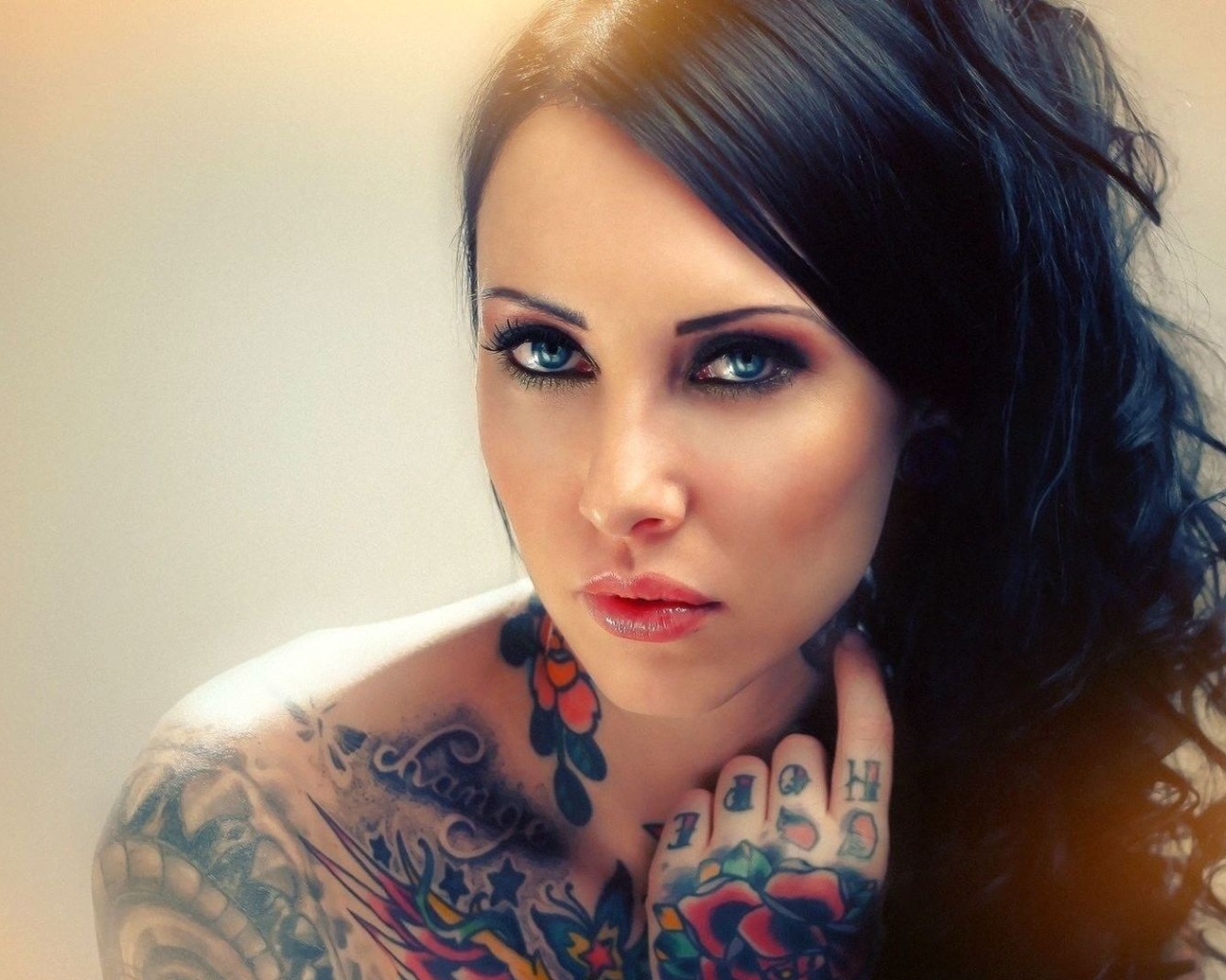 Голубоглазая девушка с татуировкой на руке и плече