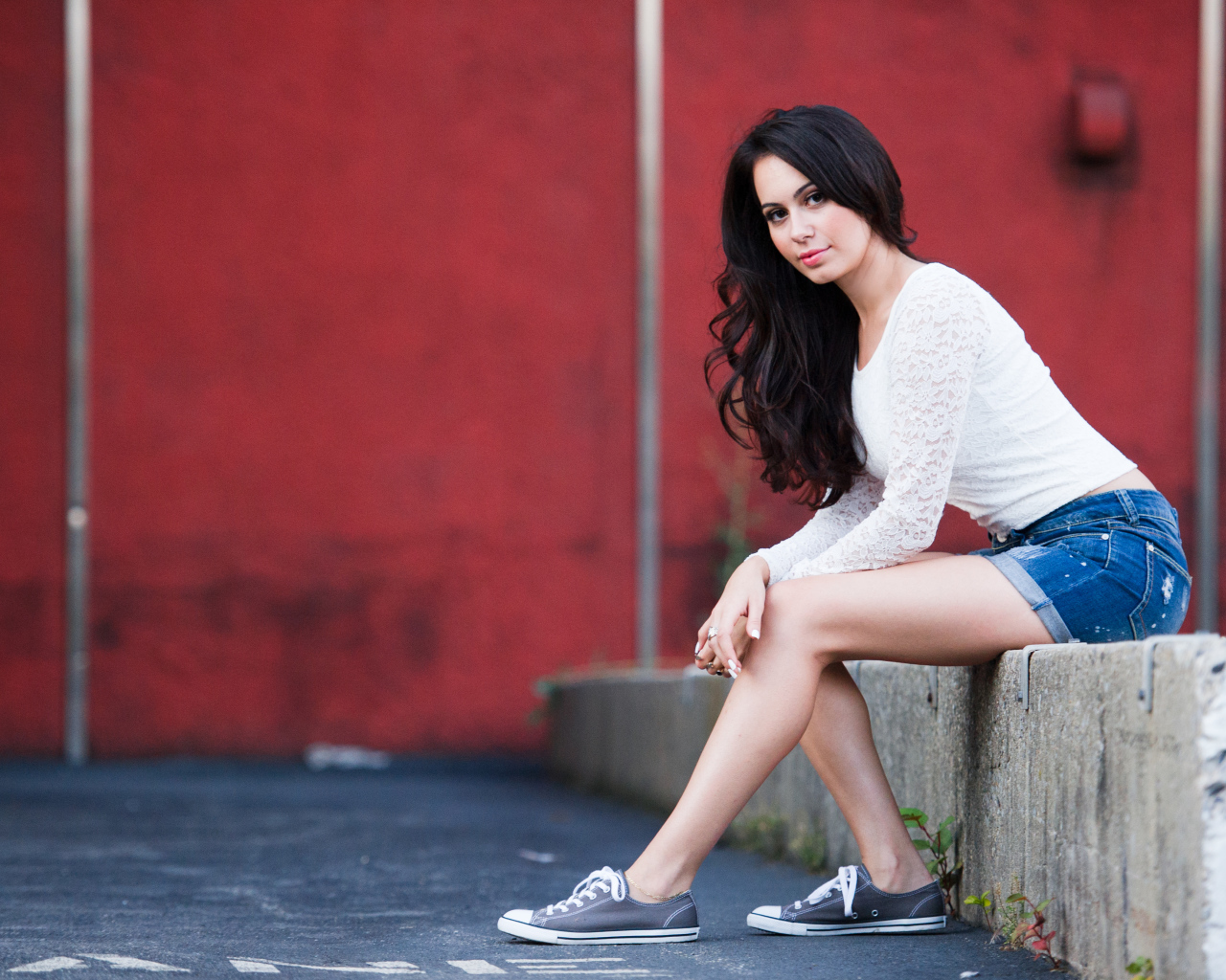 Брюнетка в кедах на бордюре