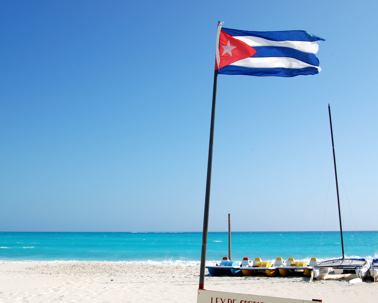 Флаг Кубы на пляже на курорте Кайо Ларго, Куба