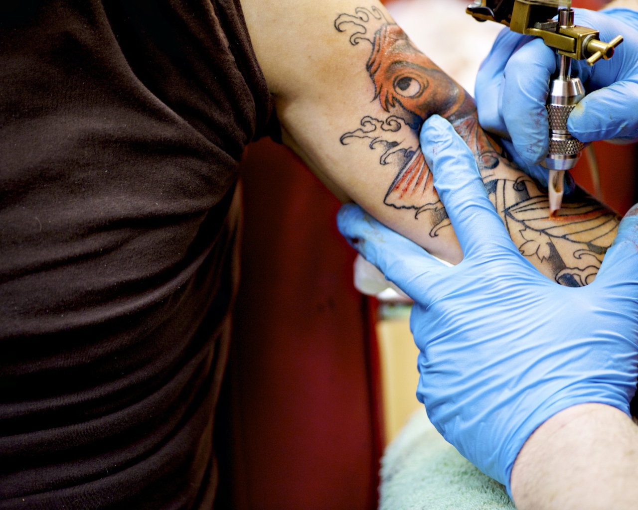 Девушке делают татуировку