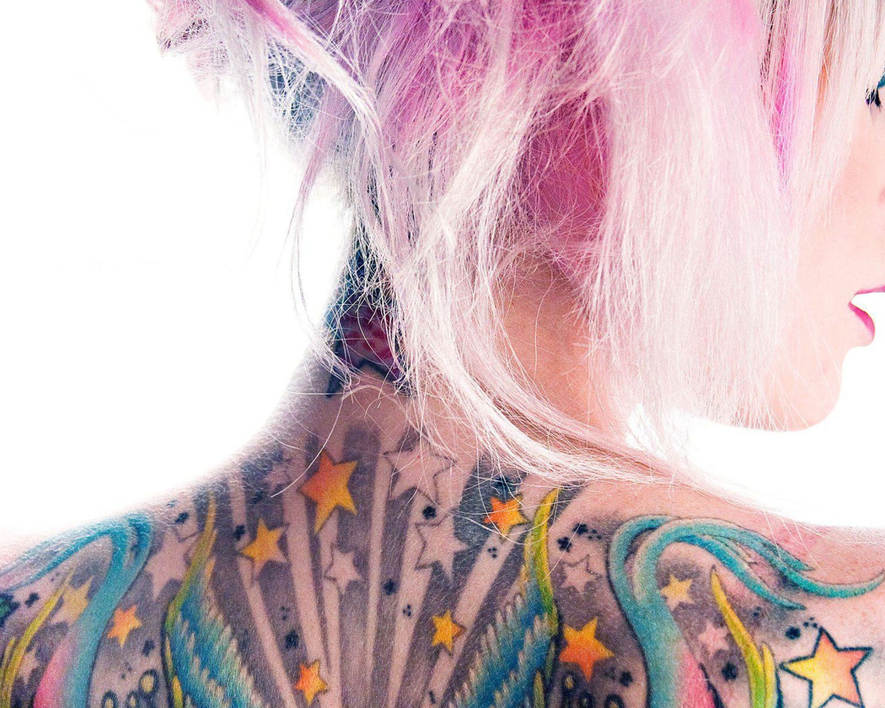 Девушка с розовыми волосами и татуировкой на спине