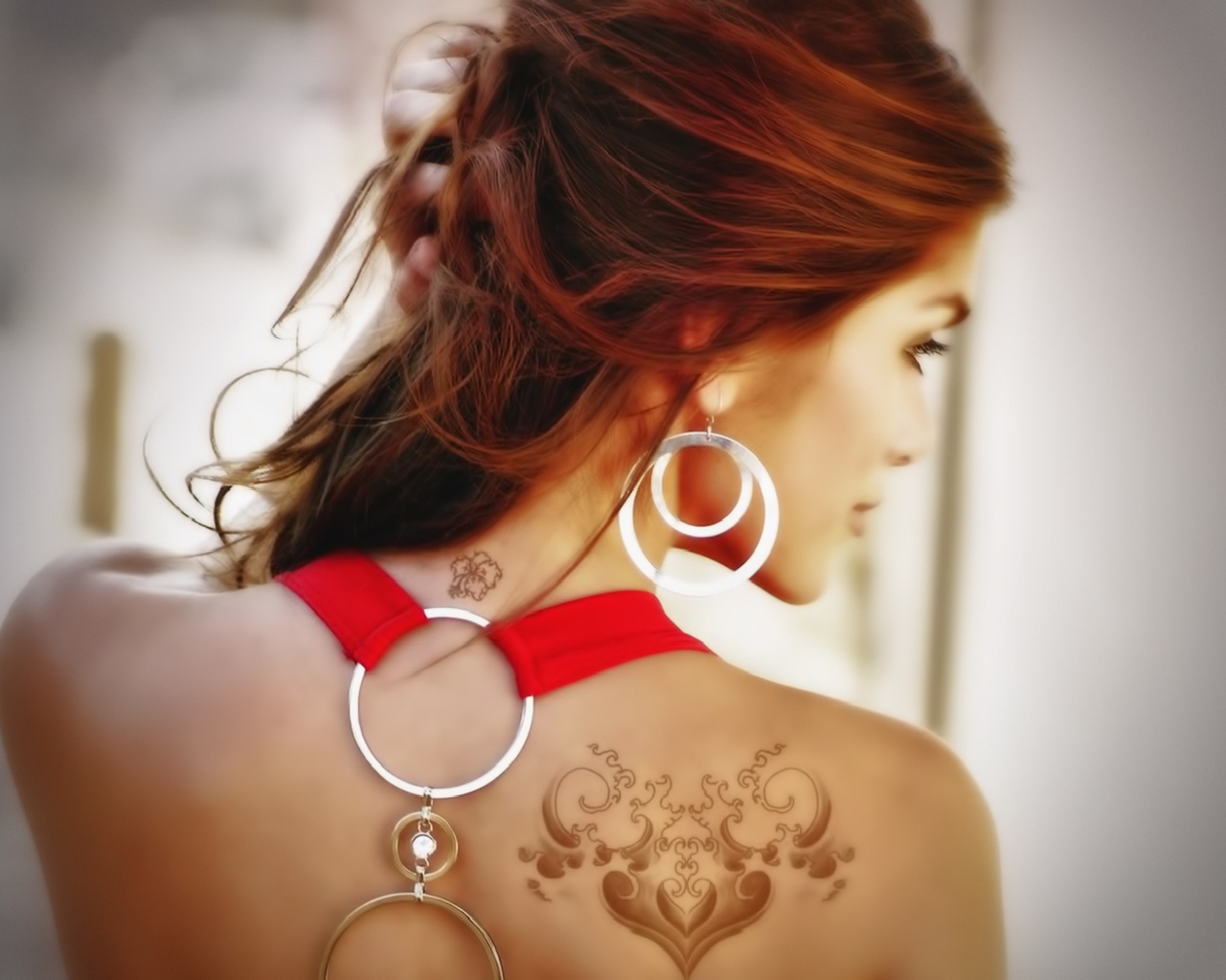 Девушка с татуировками на плече и шее