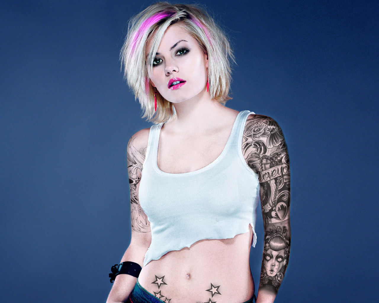 Девушка бунтарка с татуировками на руке и животе