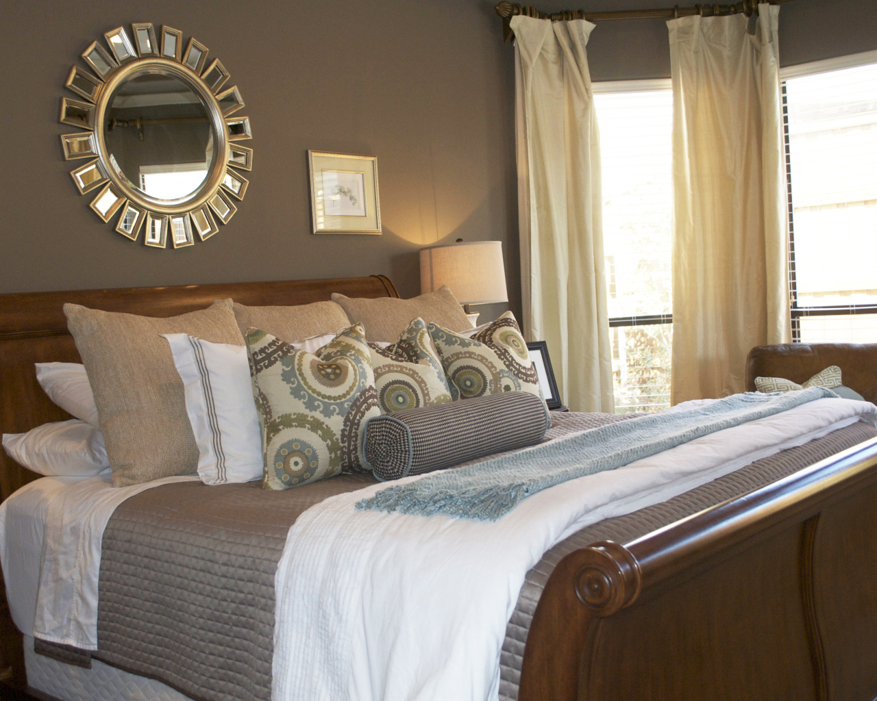 Круглое зеркало над кроватью в спальне