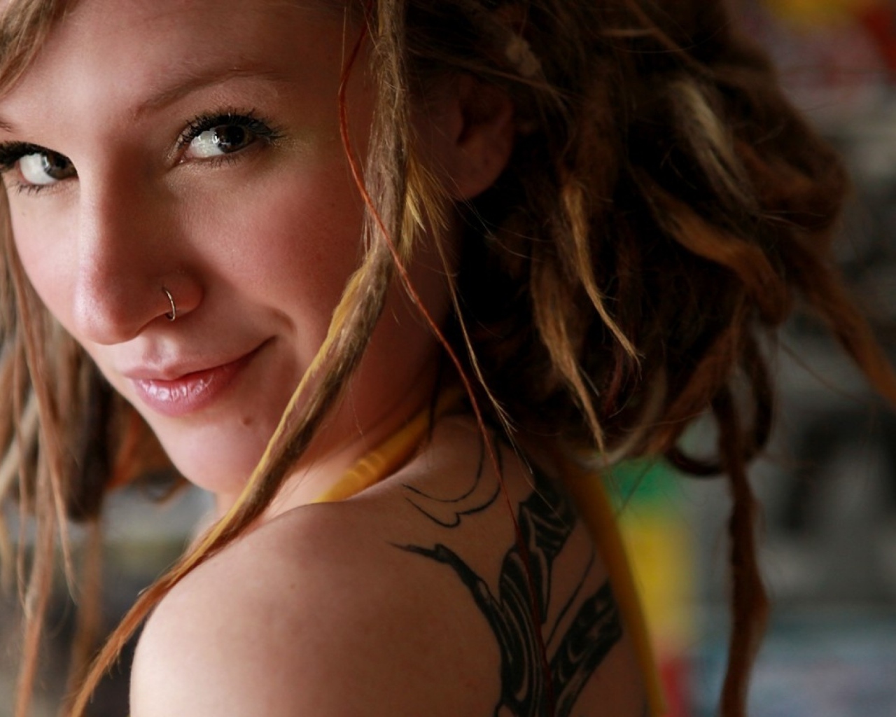 Улыбающаяся девушка с пирсингом в носу