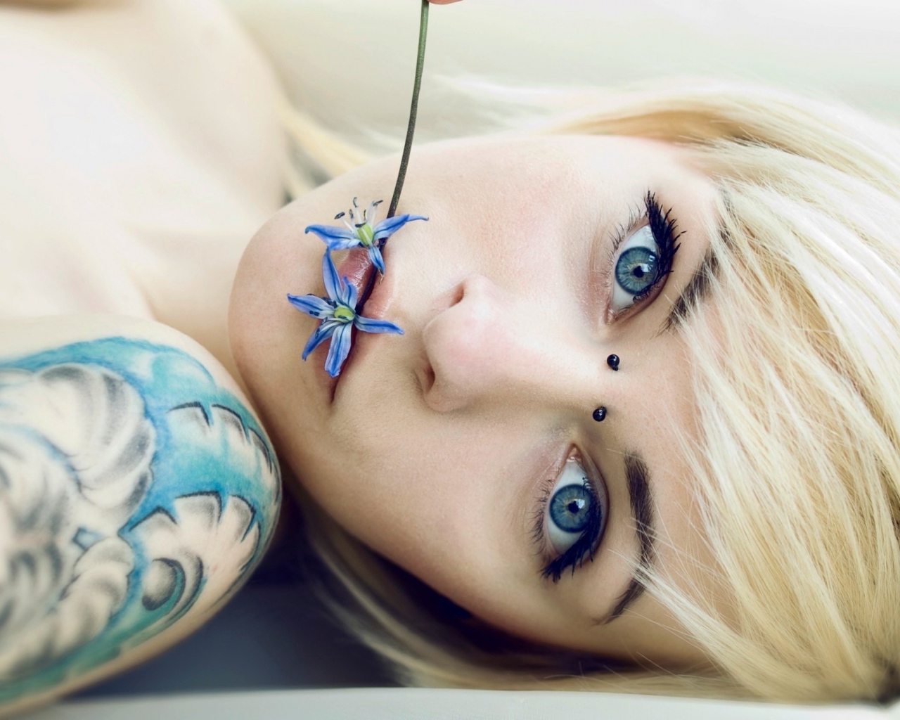 Девушка с синей татуировкой на плече