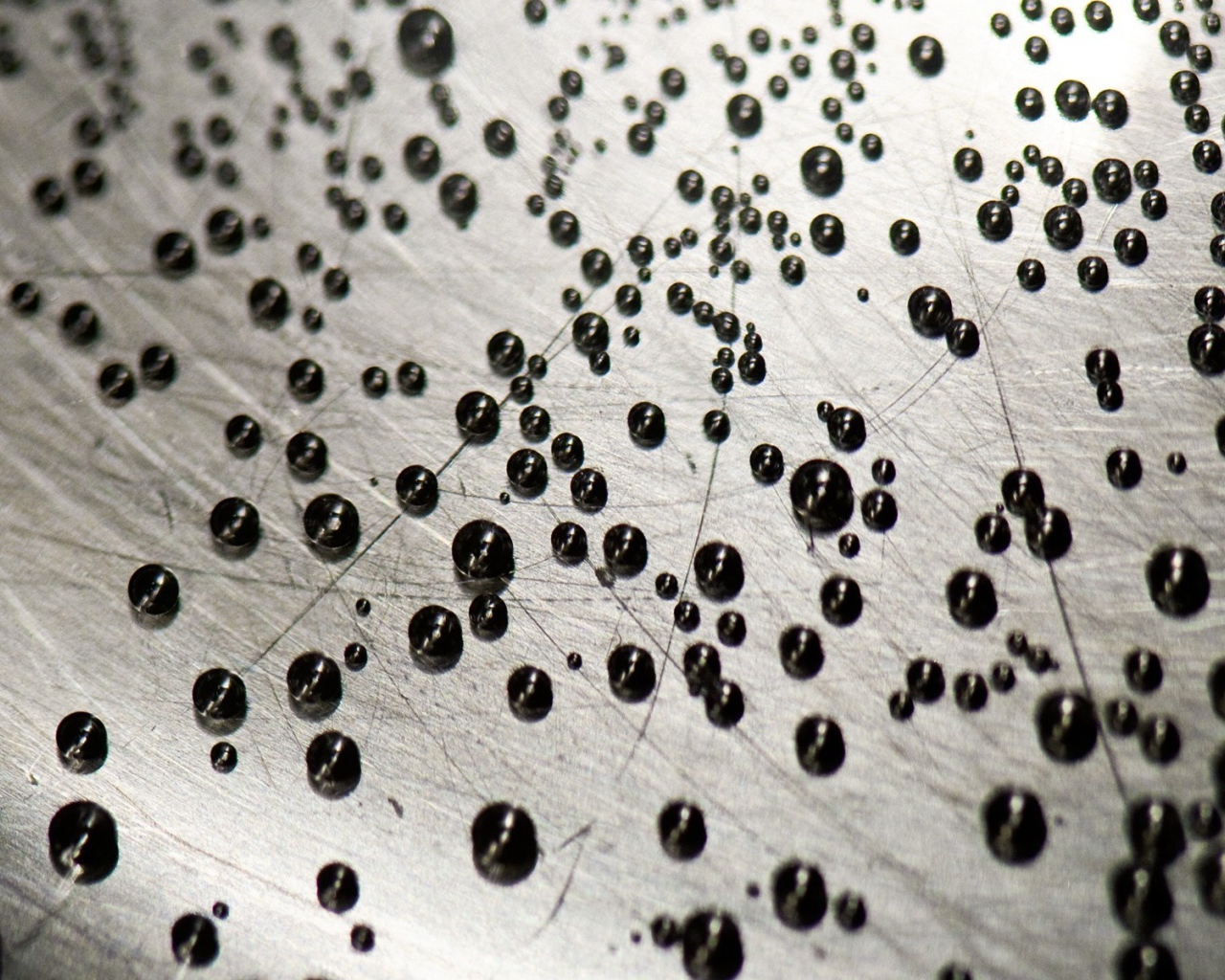 Мелкие черные шарики на серой поверхности