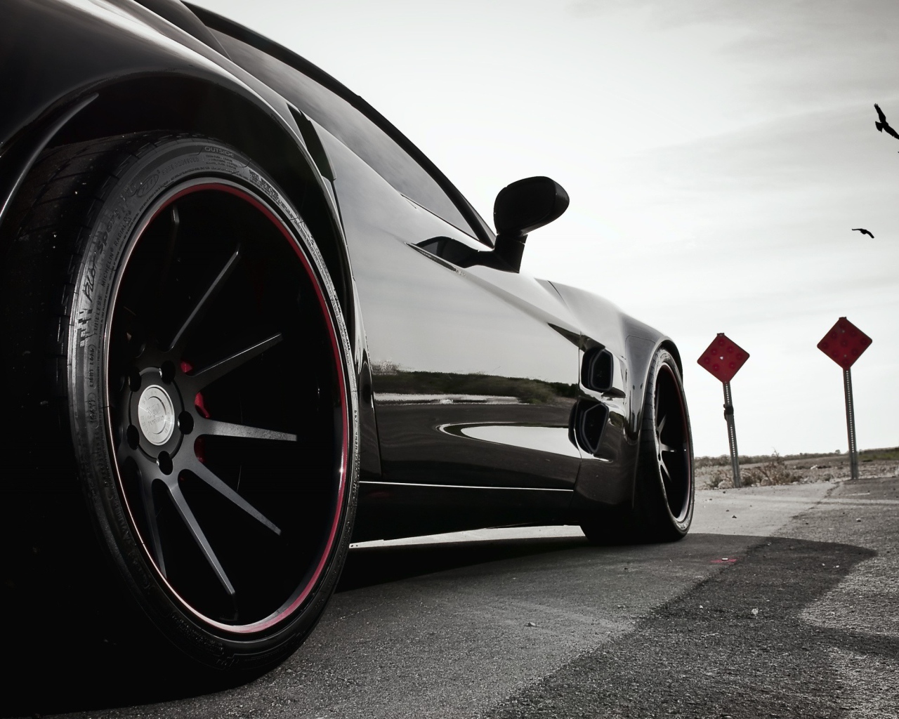 Черный автомобиль перед дорожными знаками