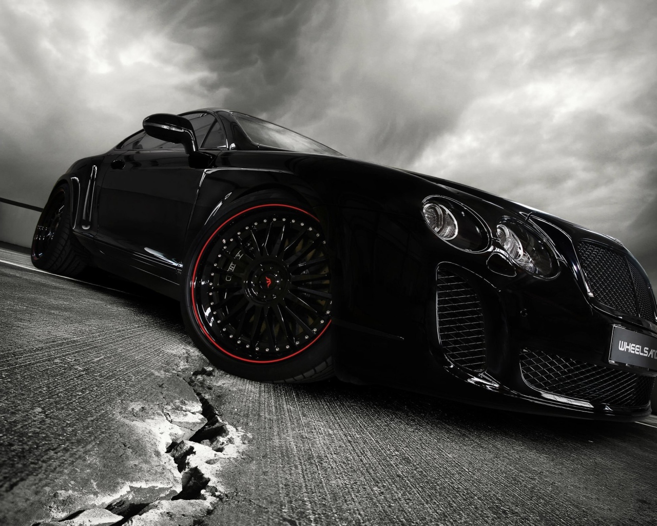 Черный автомобиль на треснувшем асфальте