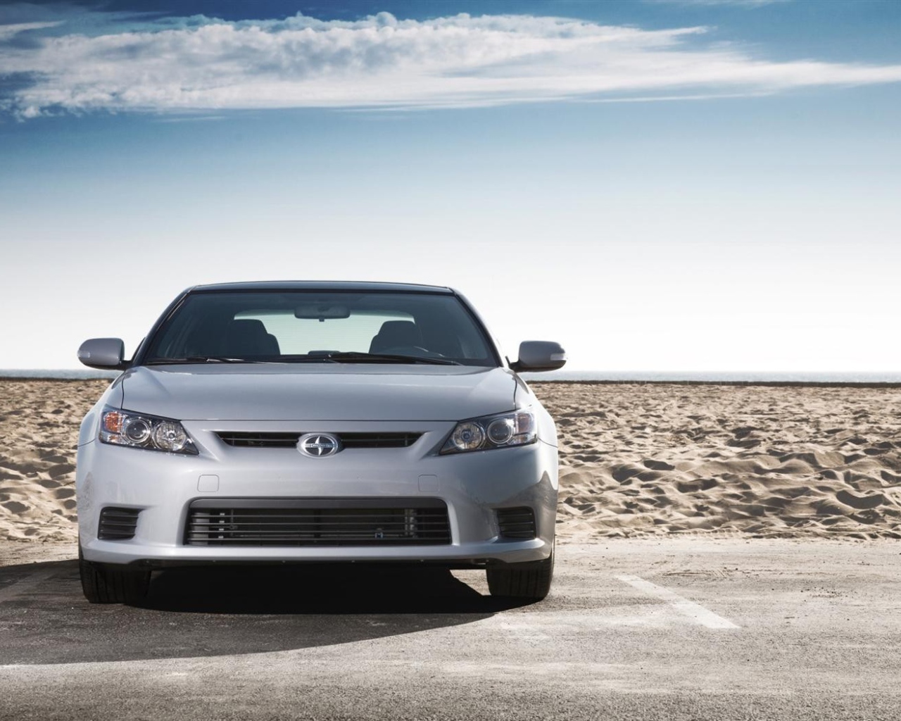 Серый Scion на фоне песка