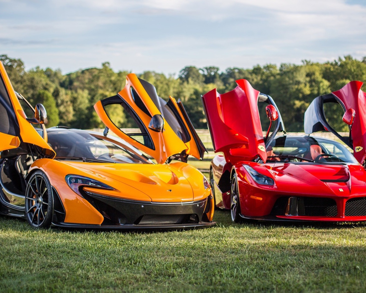 Красный Ferrari LaFerrari и оранжевый Макларен на газоне