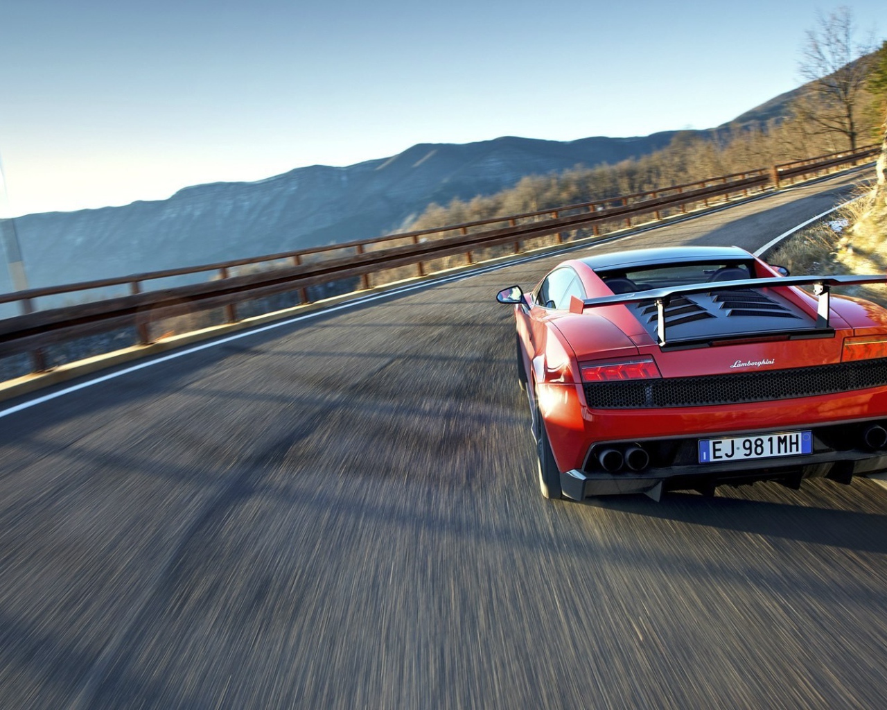 Красный гоночный автомобиль на горной дороге