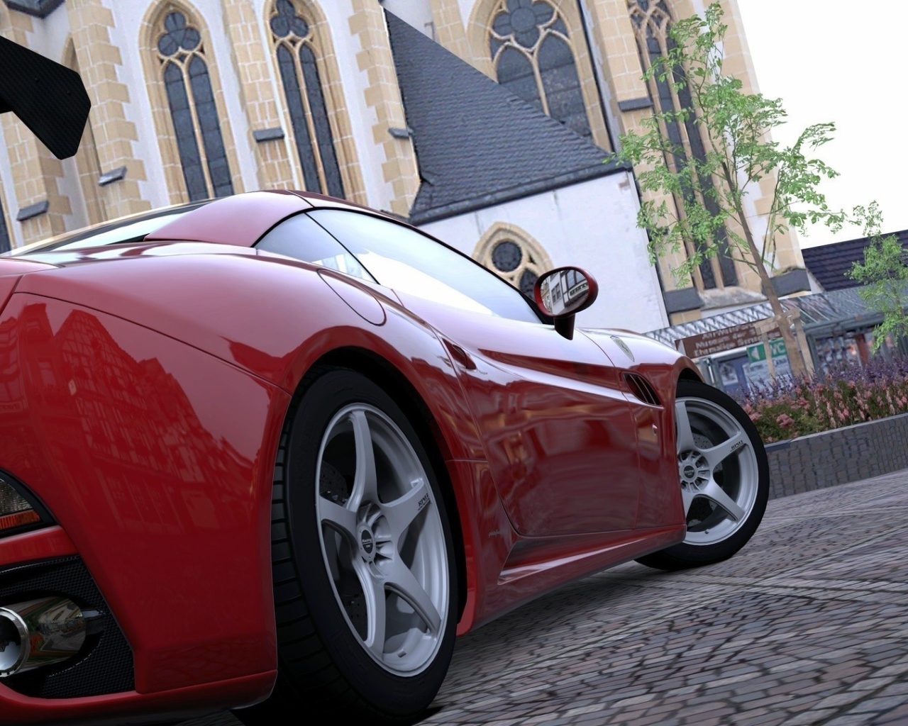 Красный спортивный автомобиль на площади у собора