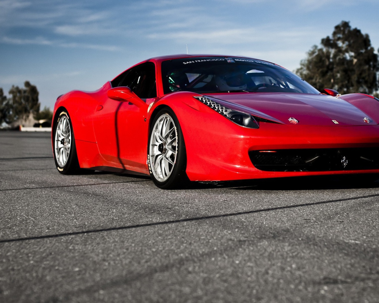 Красный спортивный автомобиль на гладком сером асфальте