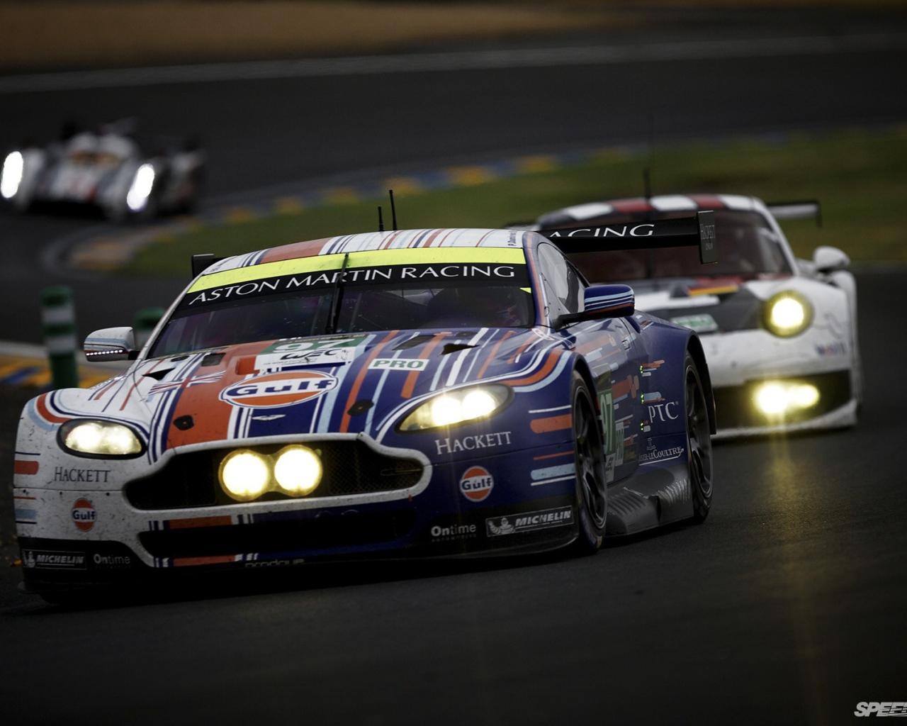 Гоночный Aston Martin с горящими фарами