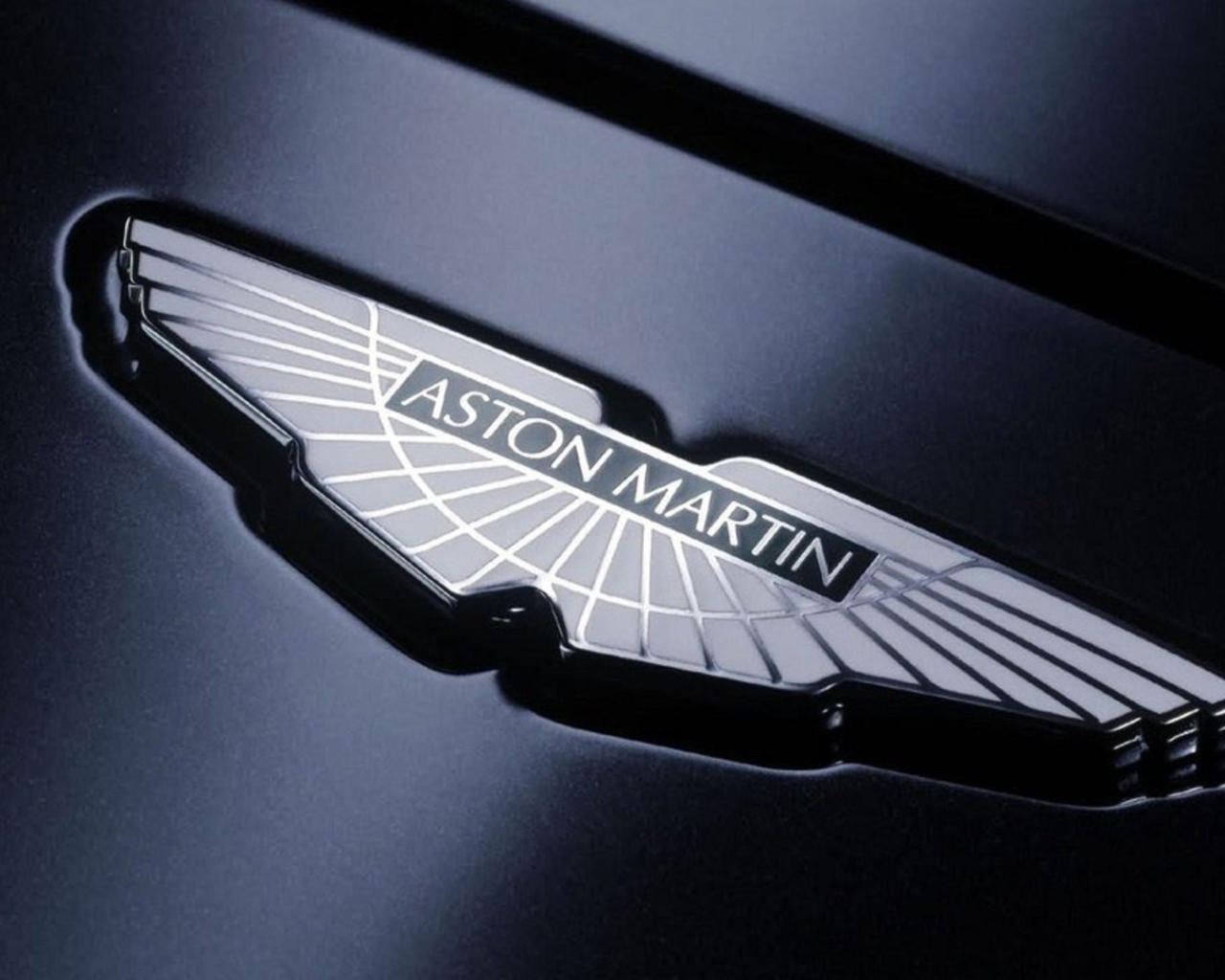 Логотип Aston Martin на черном фоне