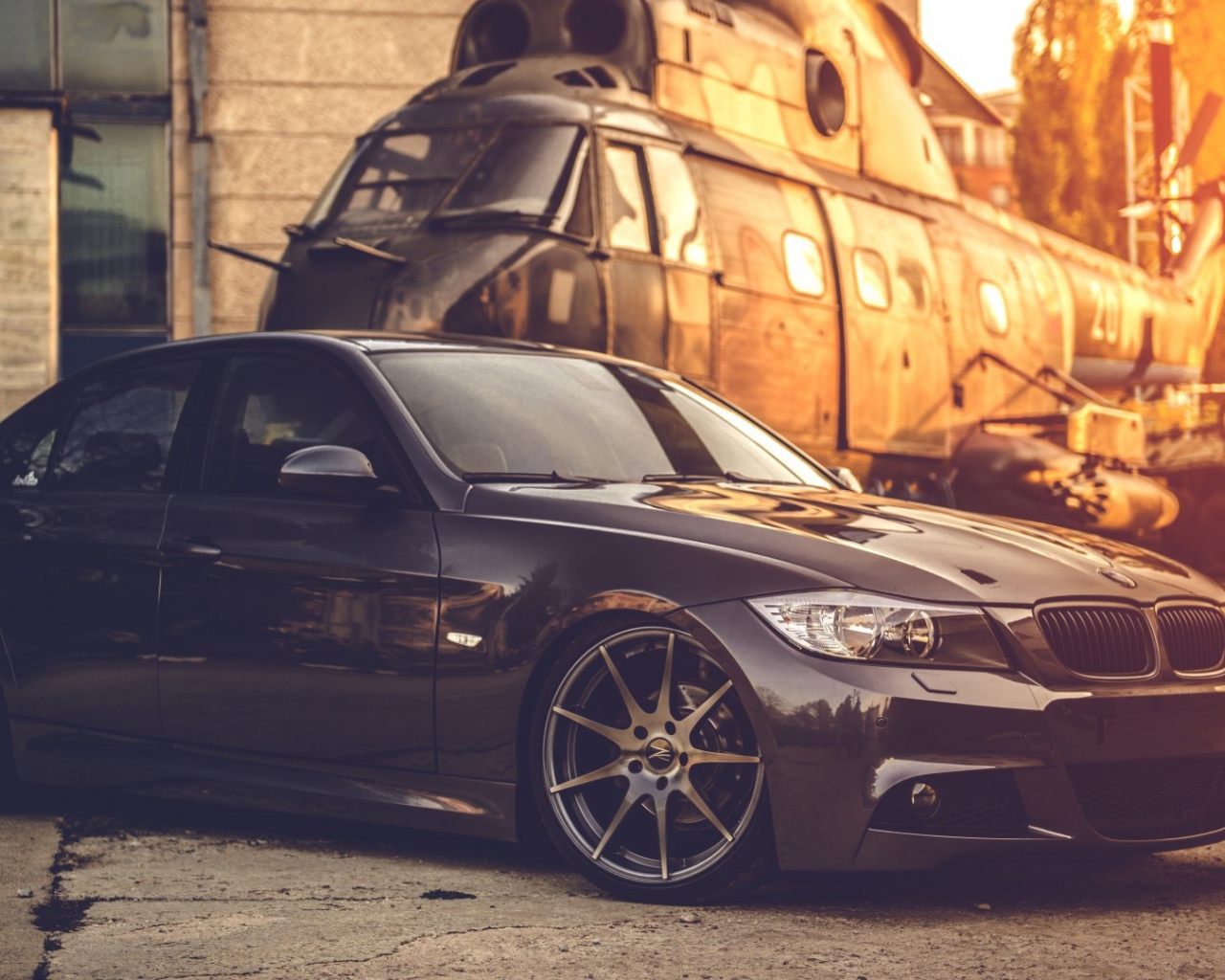 Черный БМВ на фоне вертолета