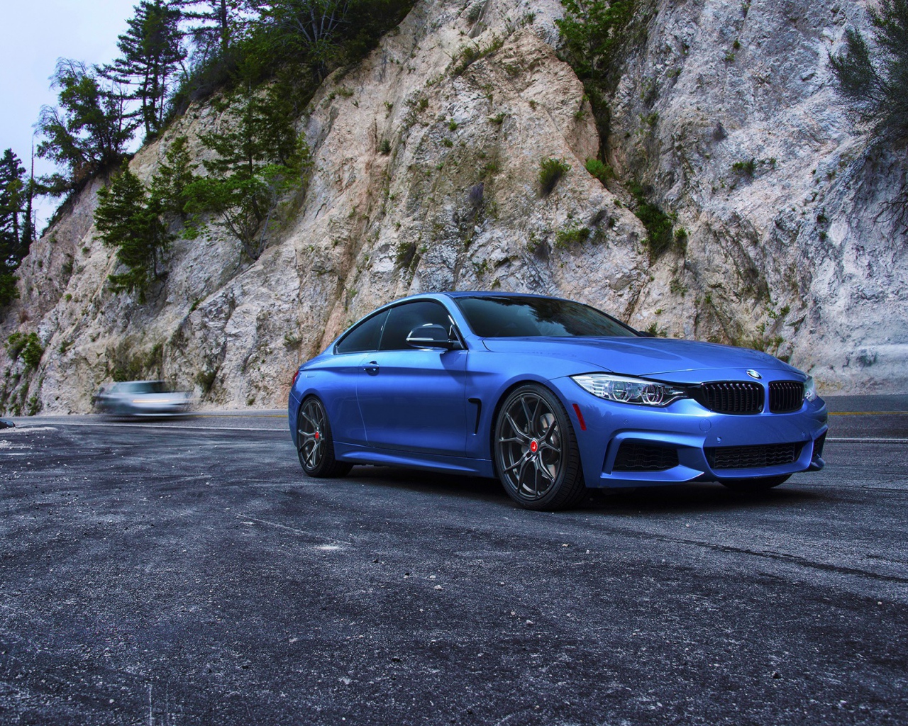 Голубой BMW M4 на фоне скалы
