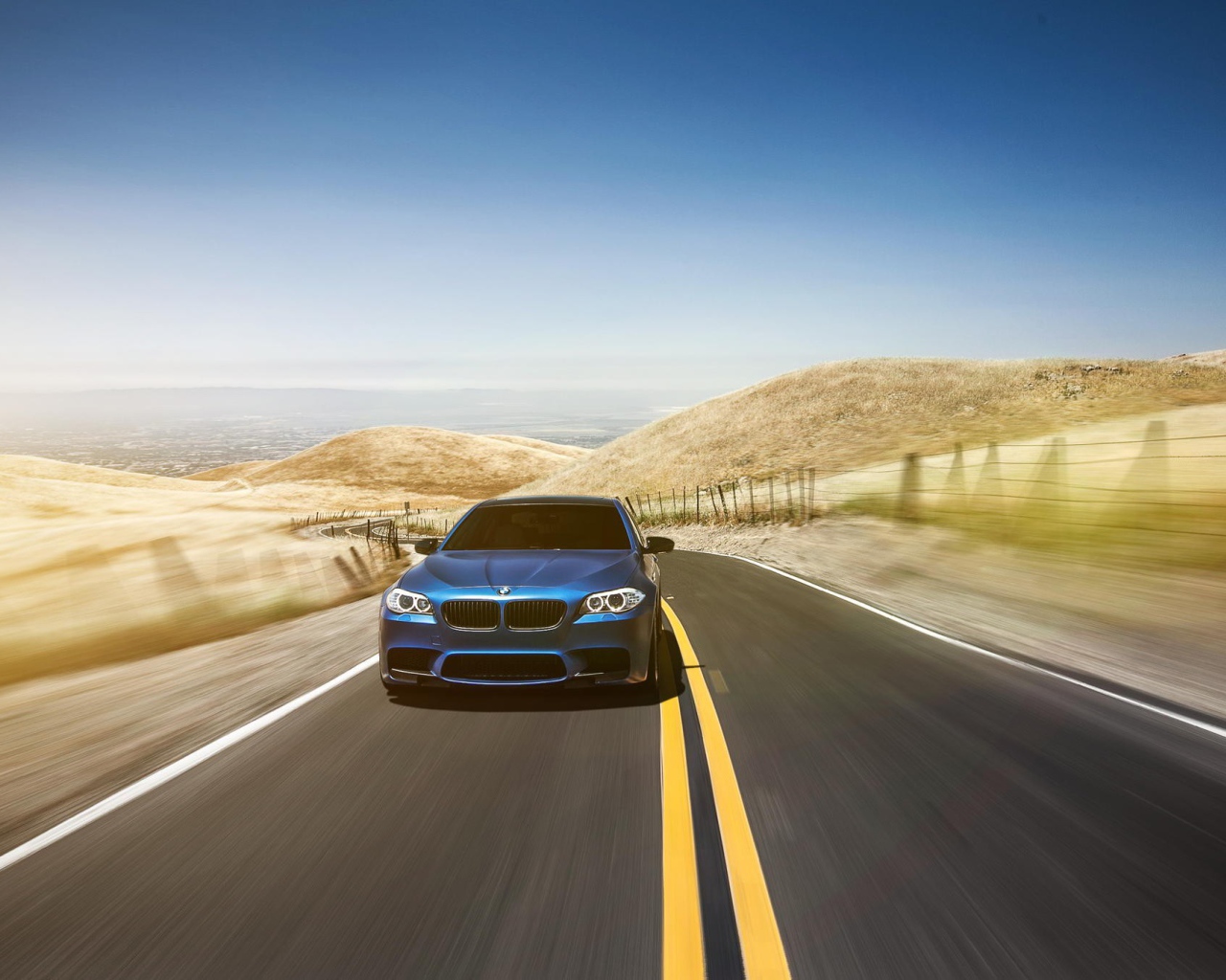 Голубой BMW мчится по шоссе в пустыне