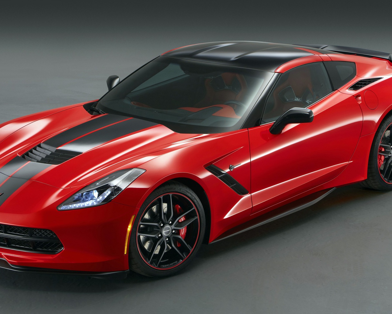 Красный Chevrolet Corvette Stingray на сером фоне