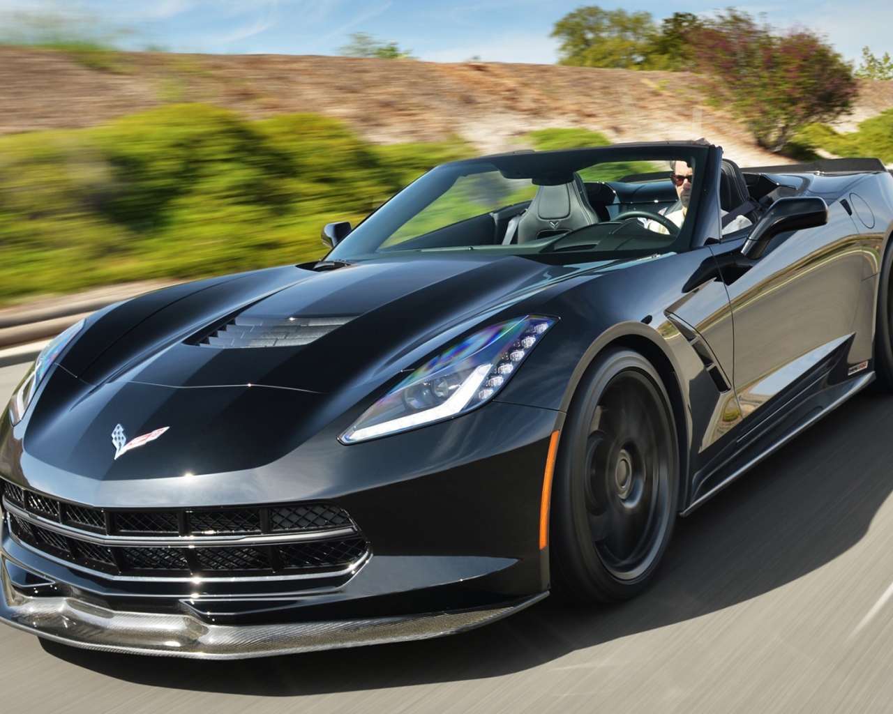 Черный кабриолет Chevrolet Corvette на шоссе