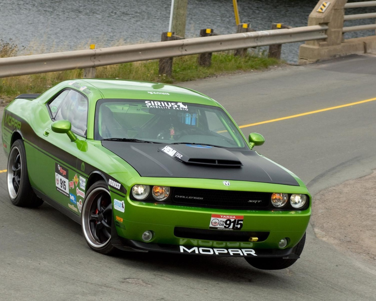 Зеленый автомобиль Dodge Challenger SRT8 на повороте