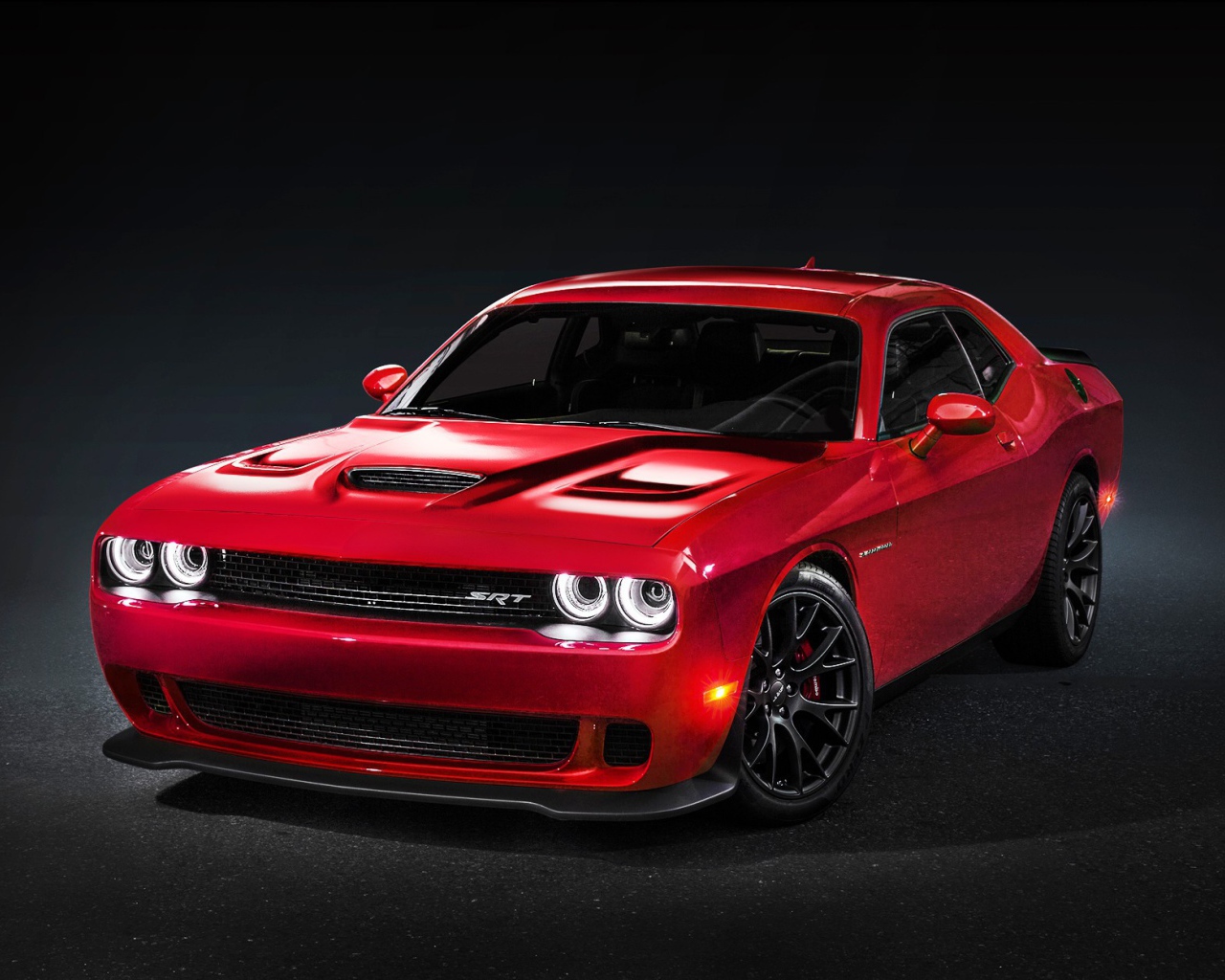 Красный Dodge Challenger Hellcat на черном фоне