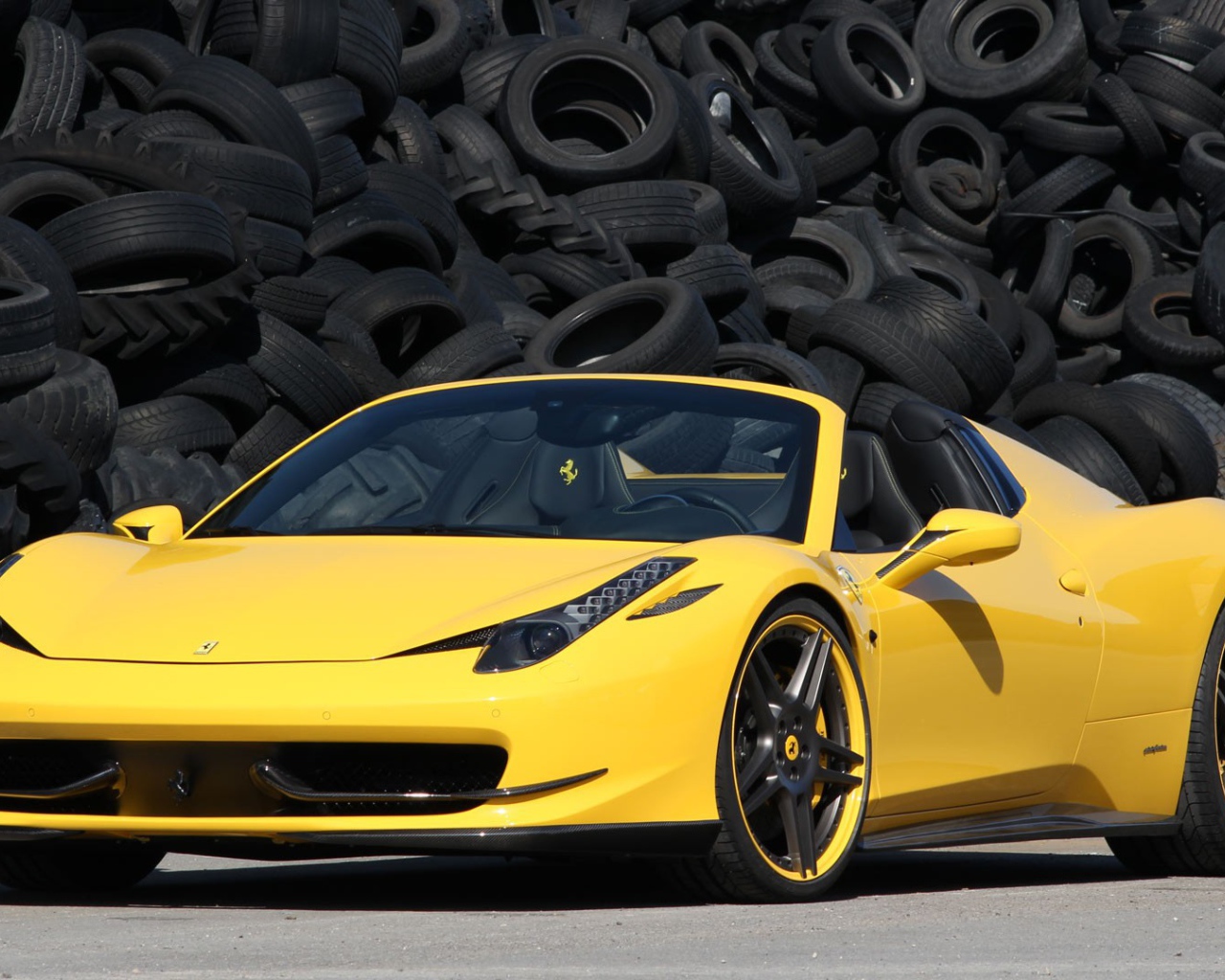 Желтый суперкар Ferrari 458 на фоне покрышек