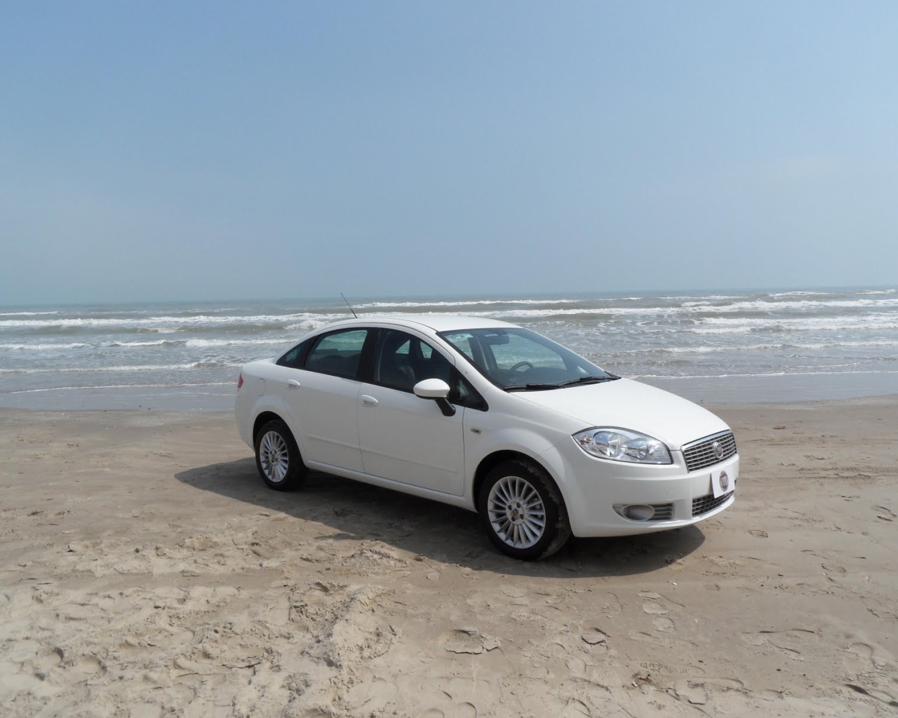 Белый Фиат на песке пляжа