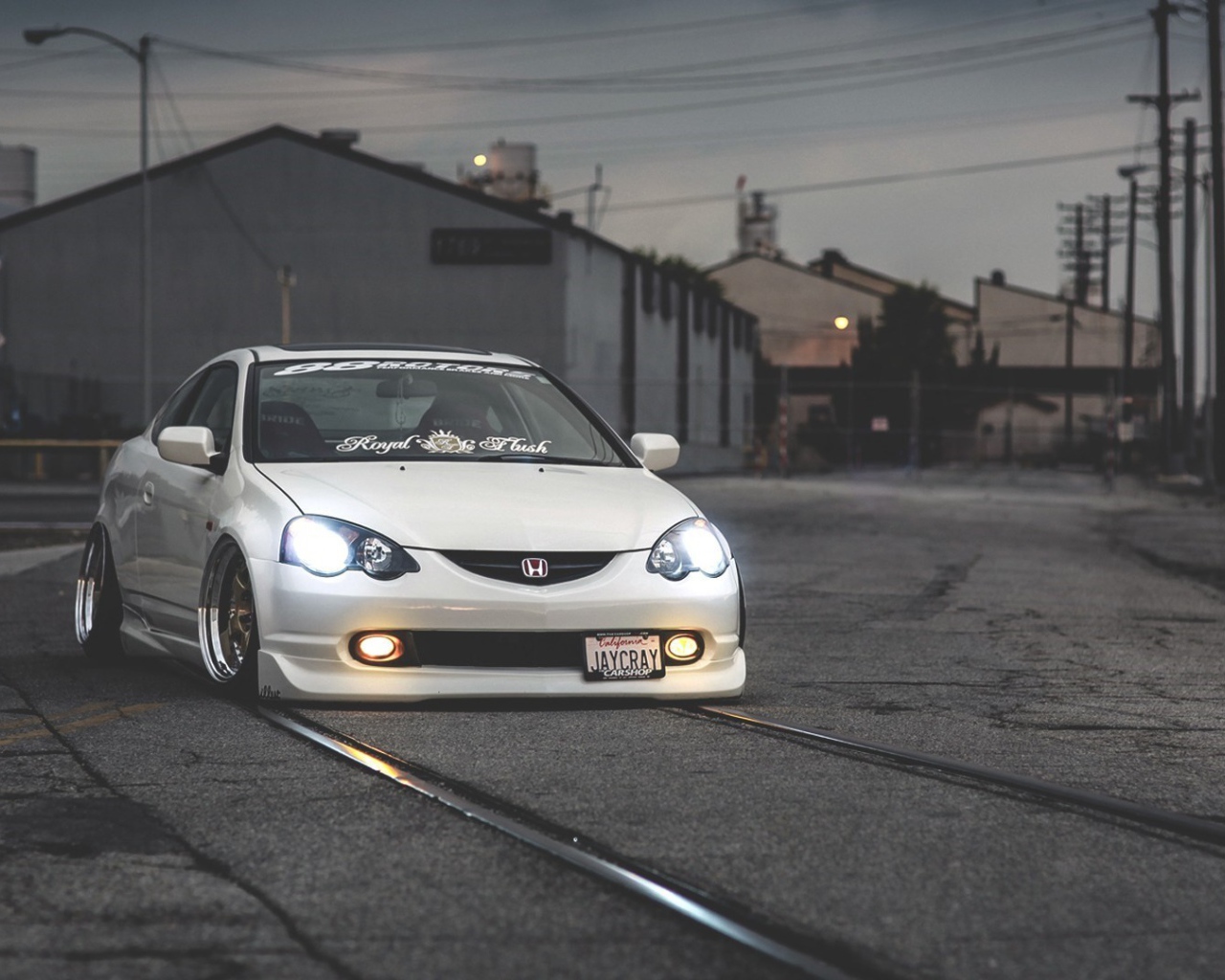 Белая Honda acura rsx на трамвайных рельсах