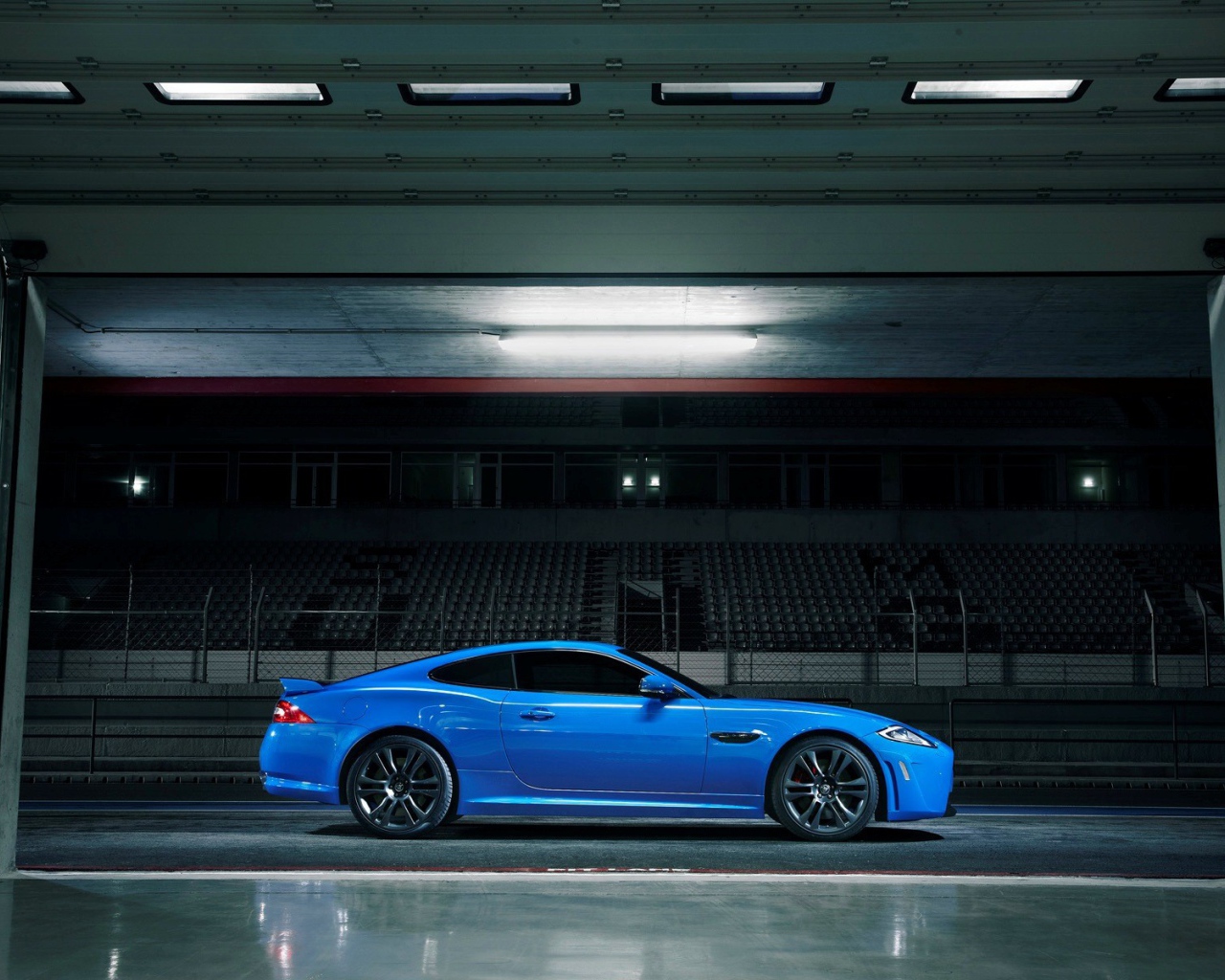 Голубой Jaguar XKR-S на стадионе