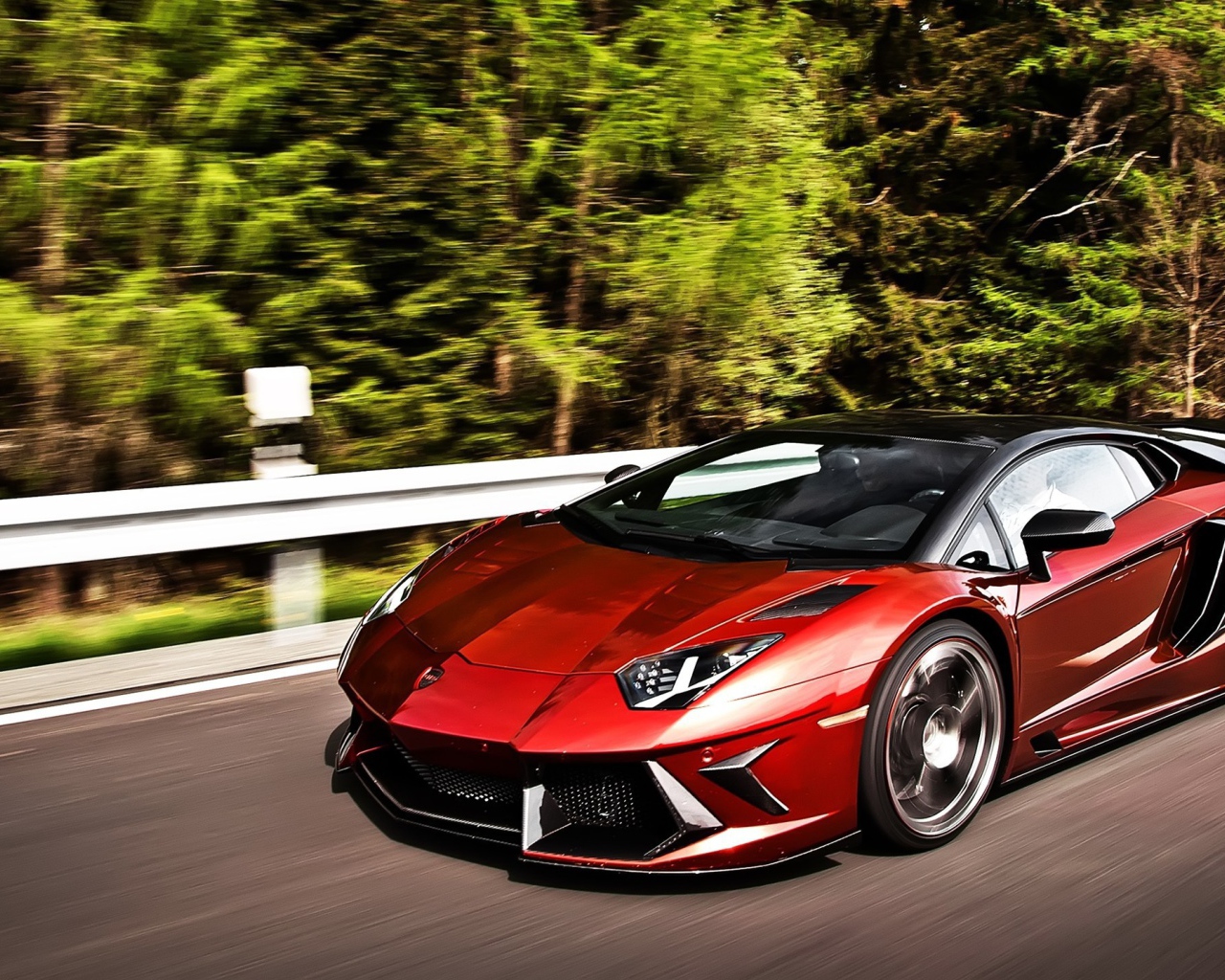 Темно красный Lamborghini Aventador на шоссе в лесу