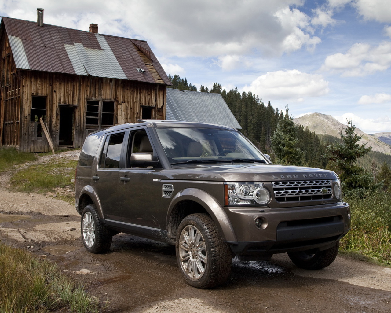 Темный Land Rover на фоне старого здания