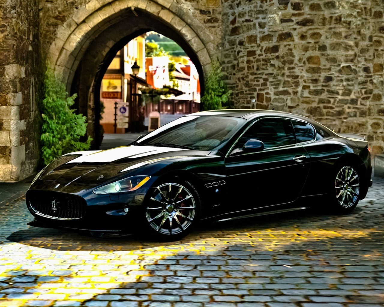 Черный Maserati gran turismo у каменной арки