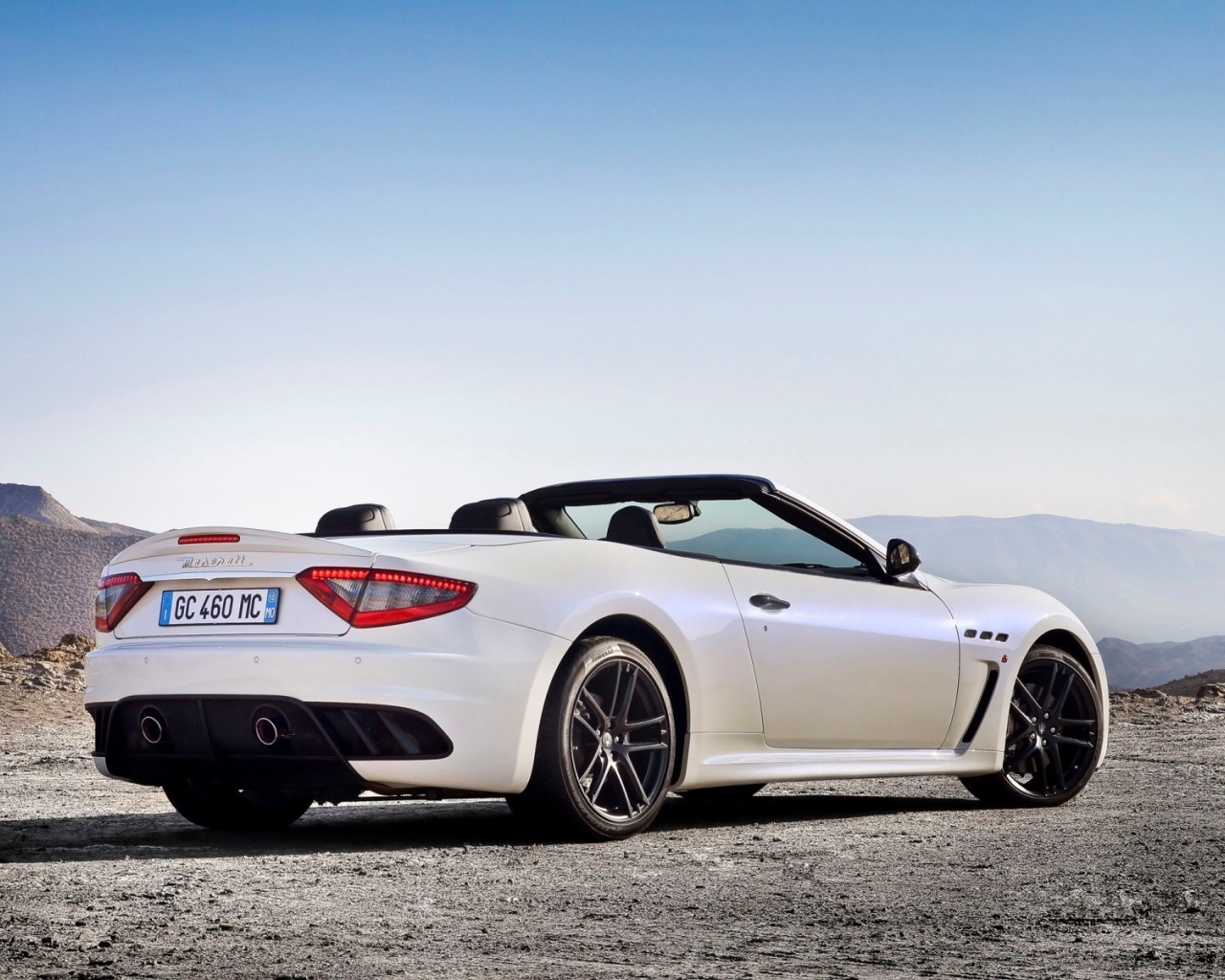Белый кабриолет Maserati на фоне гор