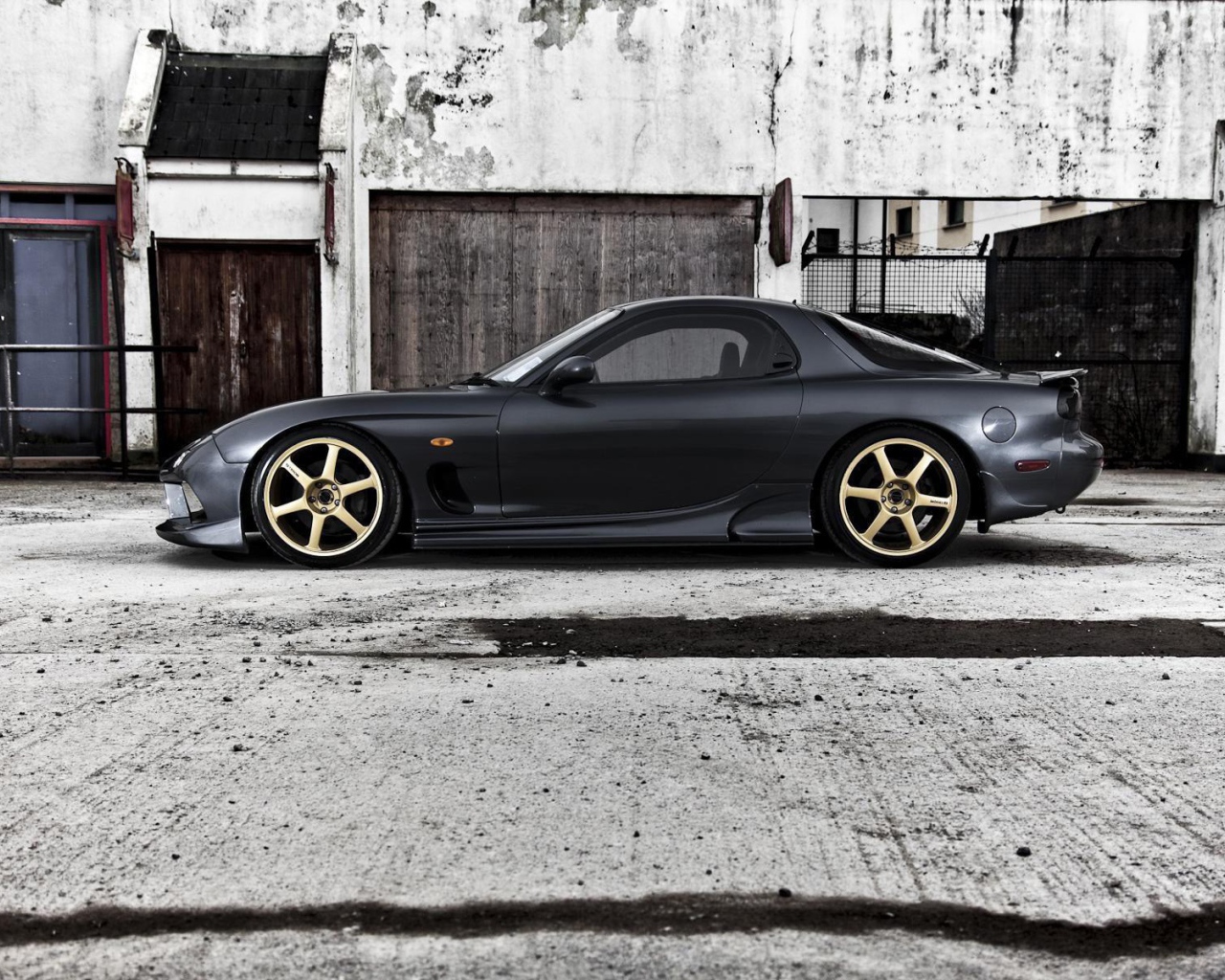 Черная Mazda RX-7 на сером бетоне