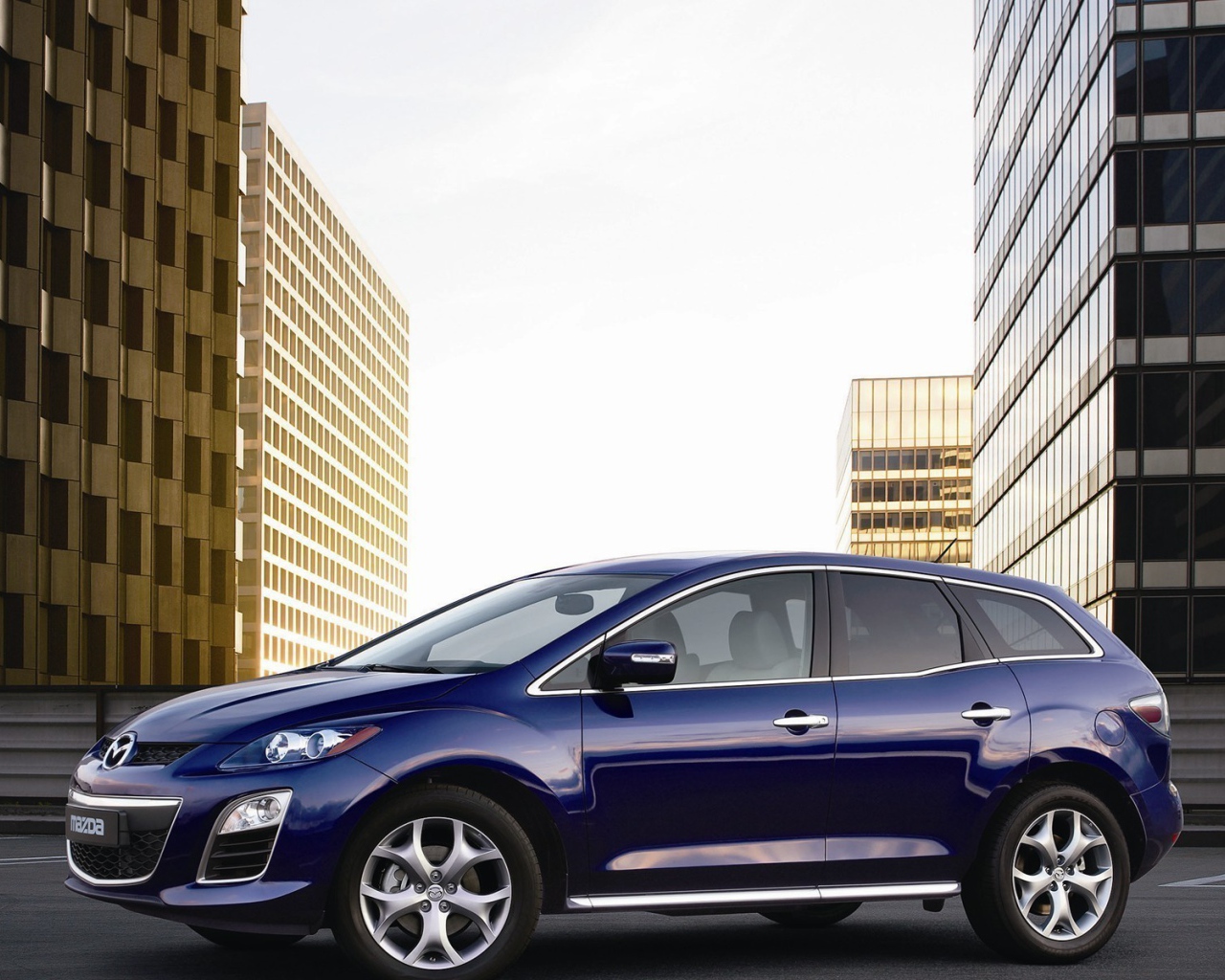 Семейный автомобиль Мазда на фоне городских зданий