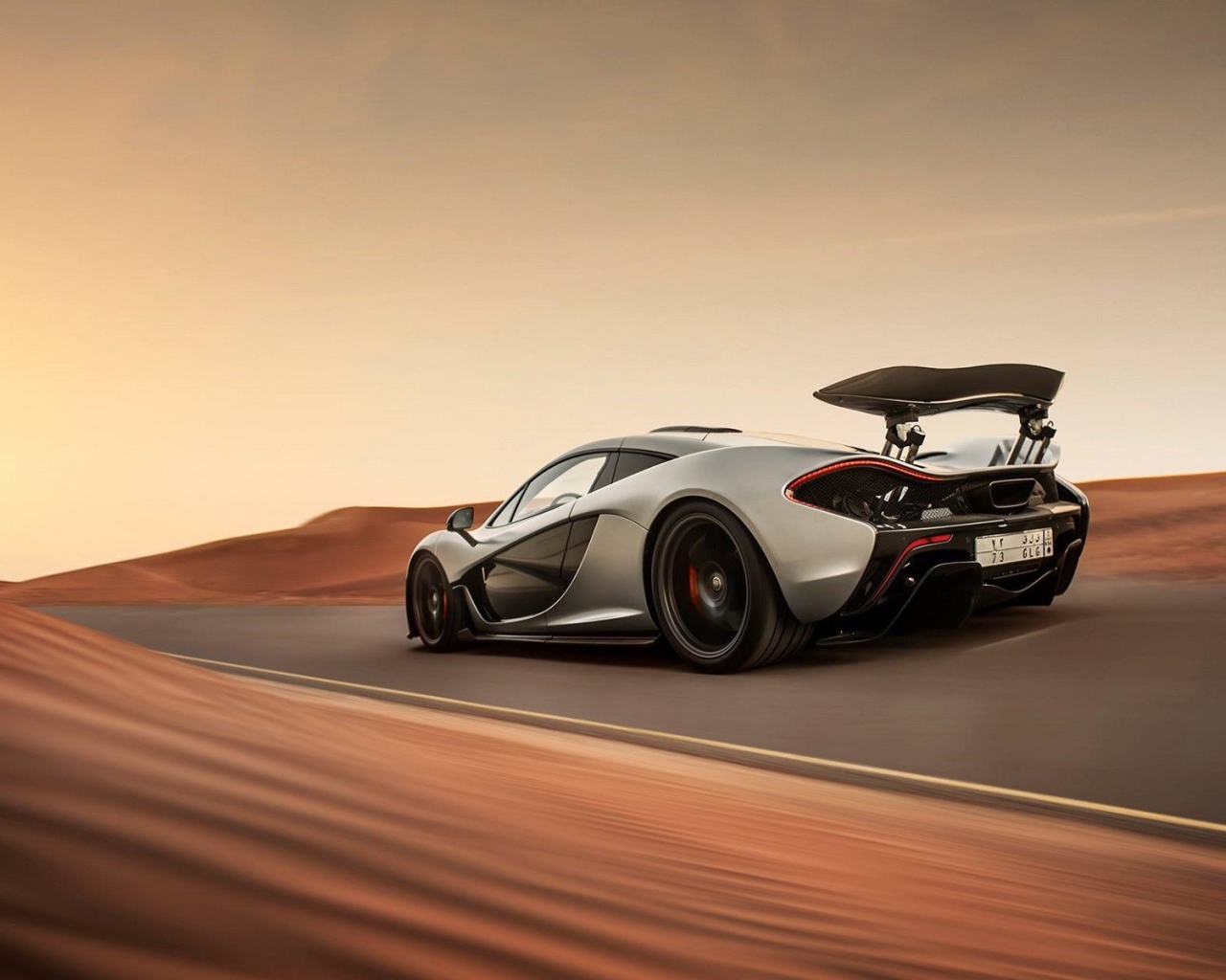 Серый McLaren P1 на шоссе в пустыне