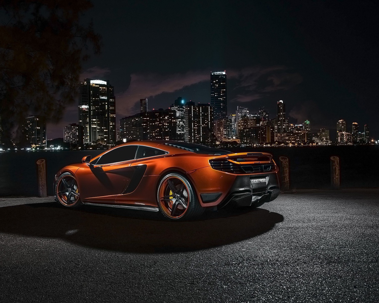 Orange McLaren MP4-12C against the backdrop of the city at night
