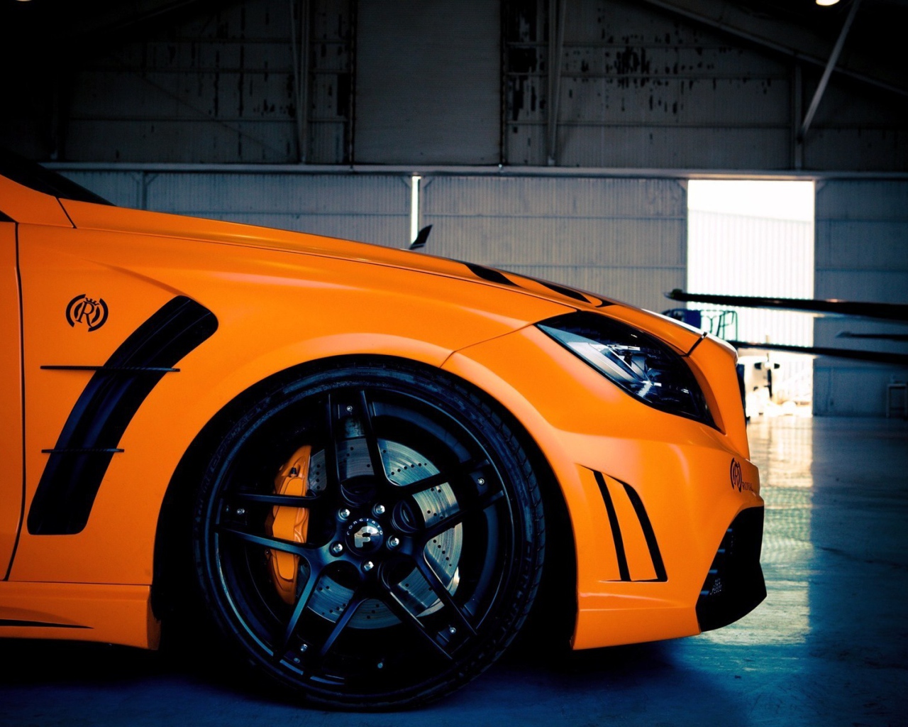 Капот и черные колеса оранжевого Mercedes-Benz CLS 63 AMG