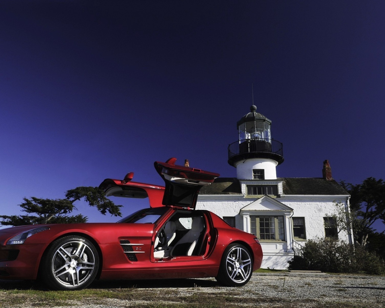Красный Mercedes SLS у маяка