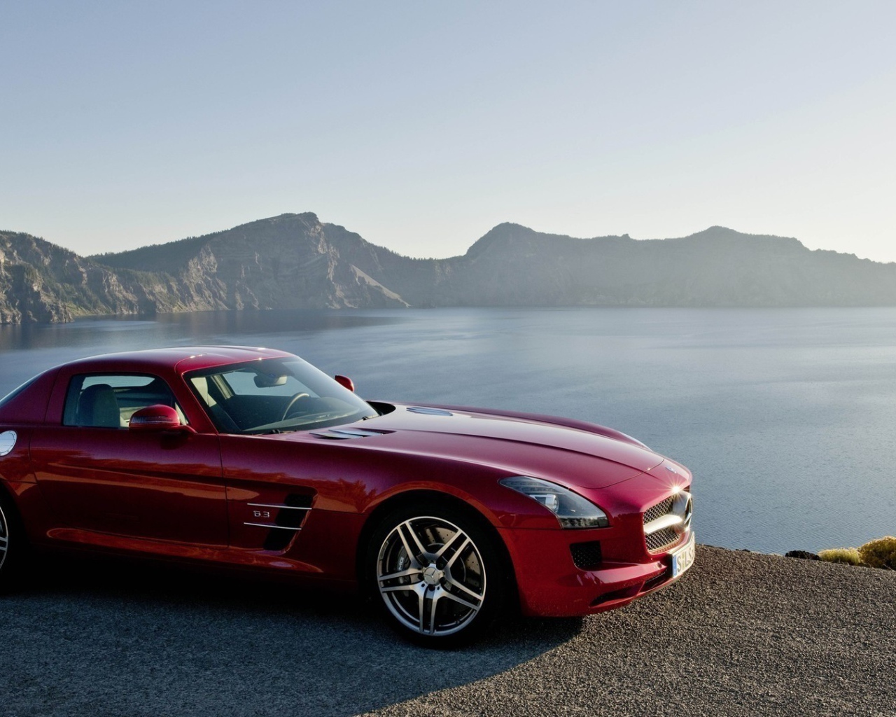 Красный Mercedes SLS на берегу озера