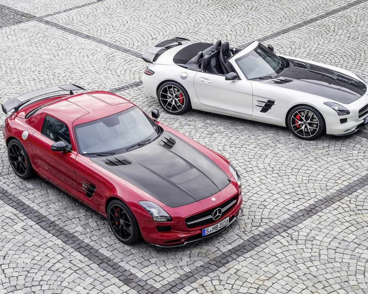Красный и белый Mercedes-Benz SLS AMG на брусчатке