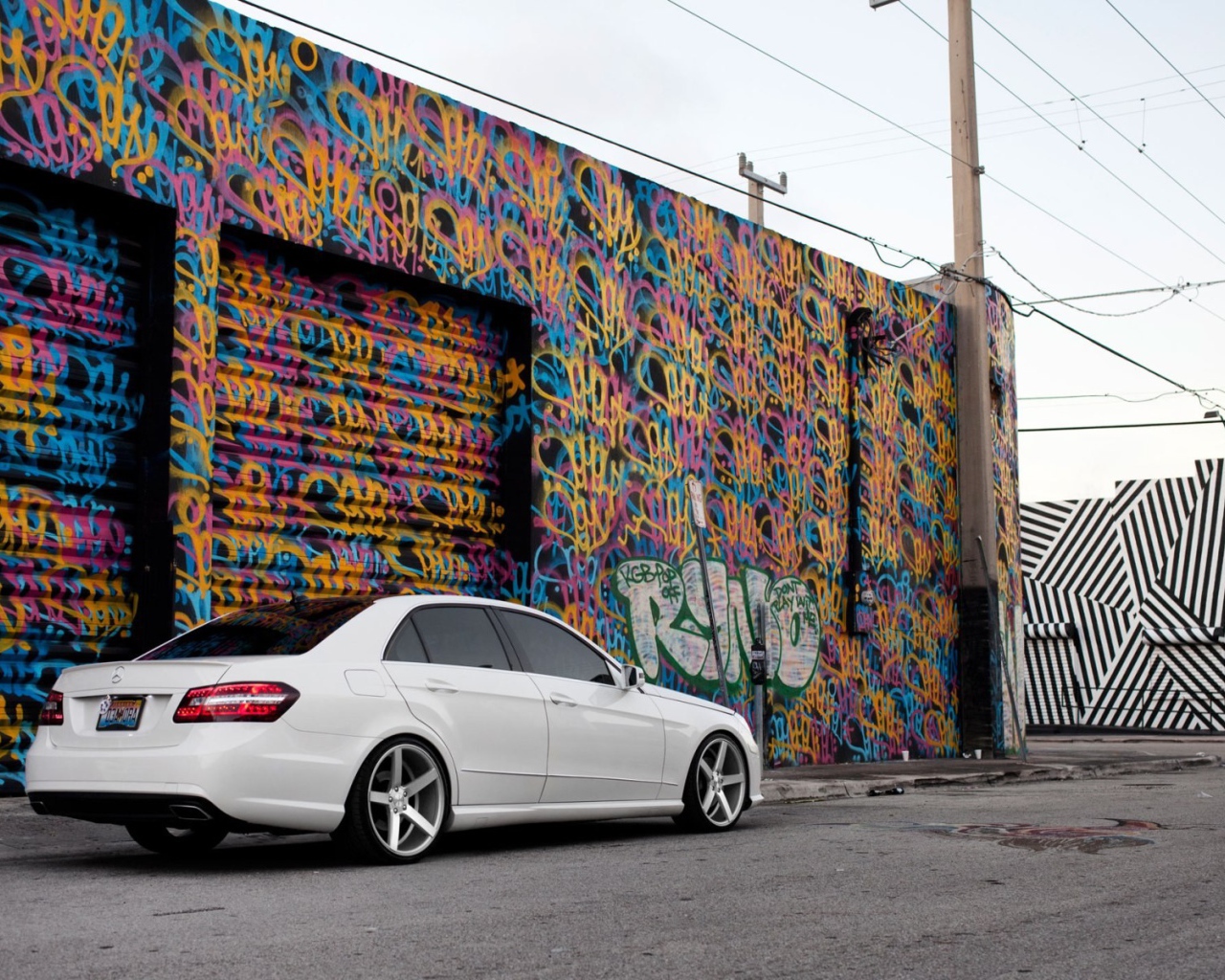 Белый Mercedes-Benz у раскрашенного гаража